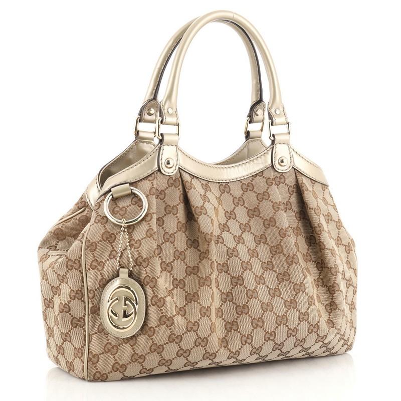 This Gucci Sukey Tote GG Canvas Medium, crafted from brown GG monogram canvas, features dual rolled leather handles, leather trim, and gold-tone hardware. Its magnetic snap closure opens to a neutral fabric interior with side zip pocket. 

Estimated