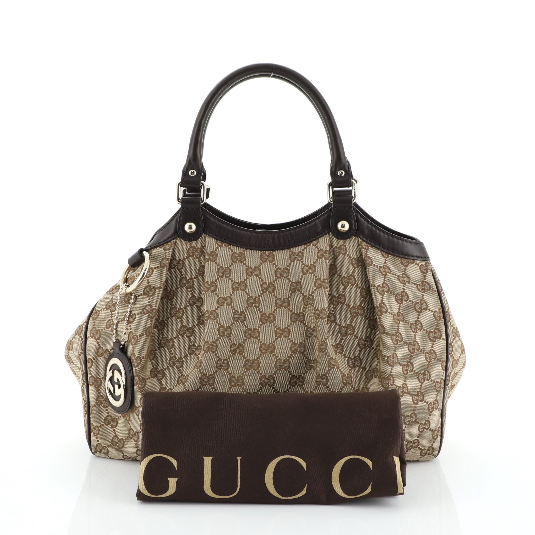 This Gucci Sukey Tote GG Canvas Medium, crafted from brown GG monogram canvas, features dual rolled leather handles, leather trim, and gold-tone hardware. Its magnetic snap closure opens to a brown fabric interior with side zip pocket. 

Estimated