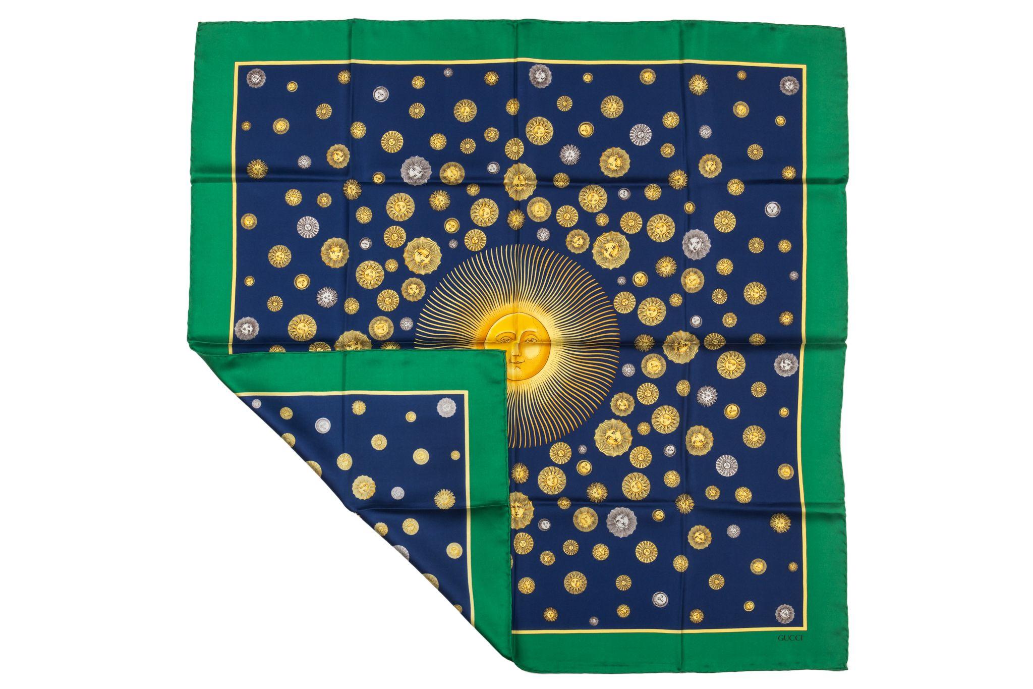 Gucci silk scarf in blue with a green frame. The pattern shows several suns. The item is in excellent condition.