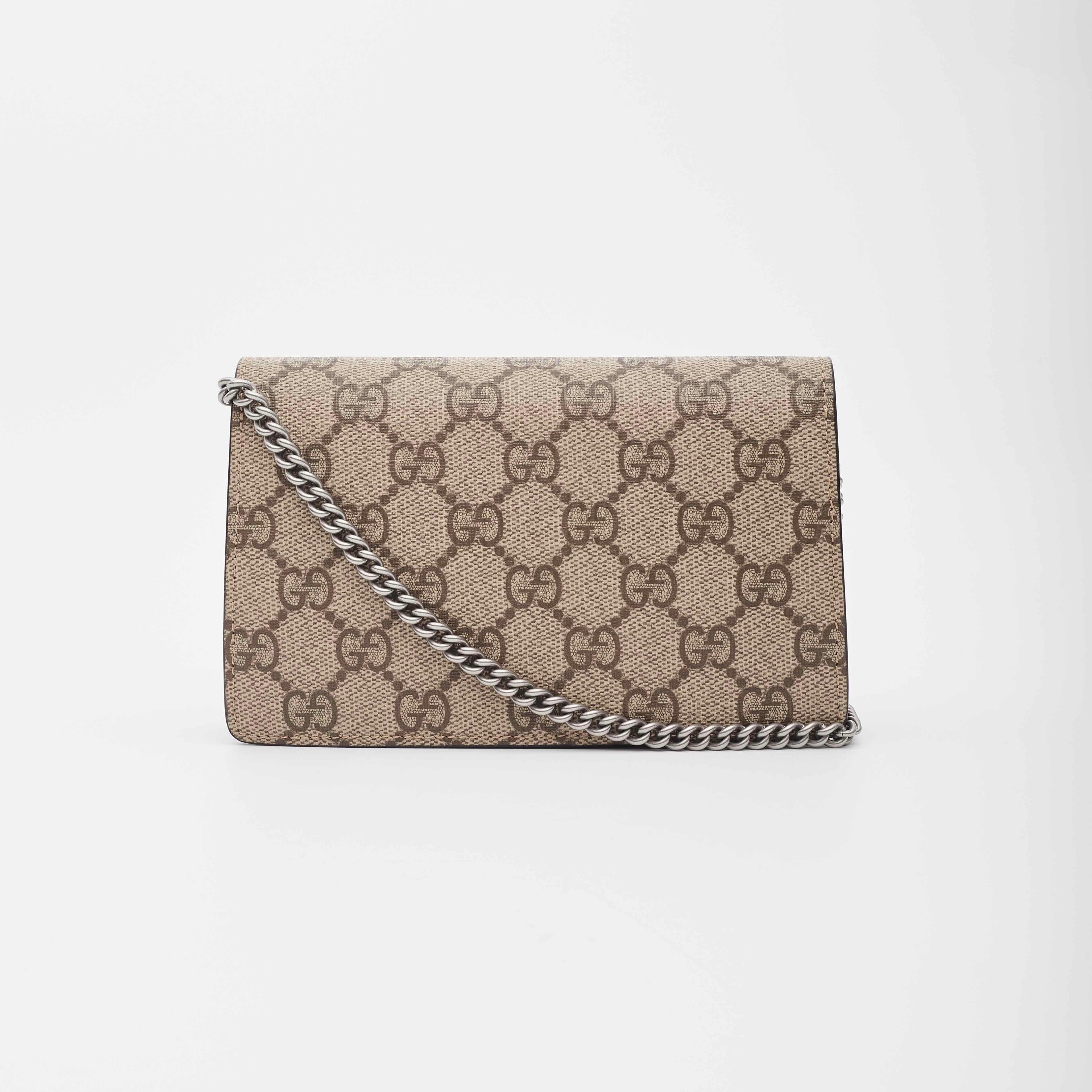 This petite bag is made of signature Gucci monogram coated canvas. This bag features a silver chain shoulder strap, a textured horseshoe tiger spur on the front flap, snap closure and a beige suede interior lining with a key chain clasp that can