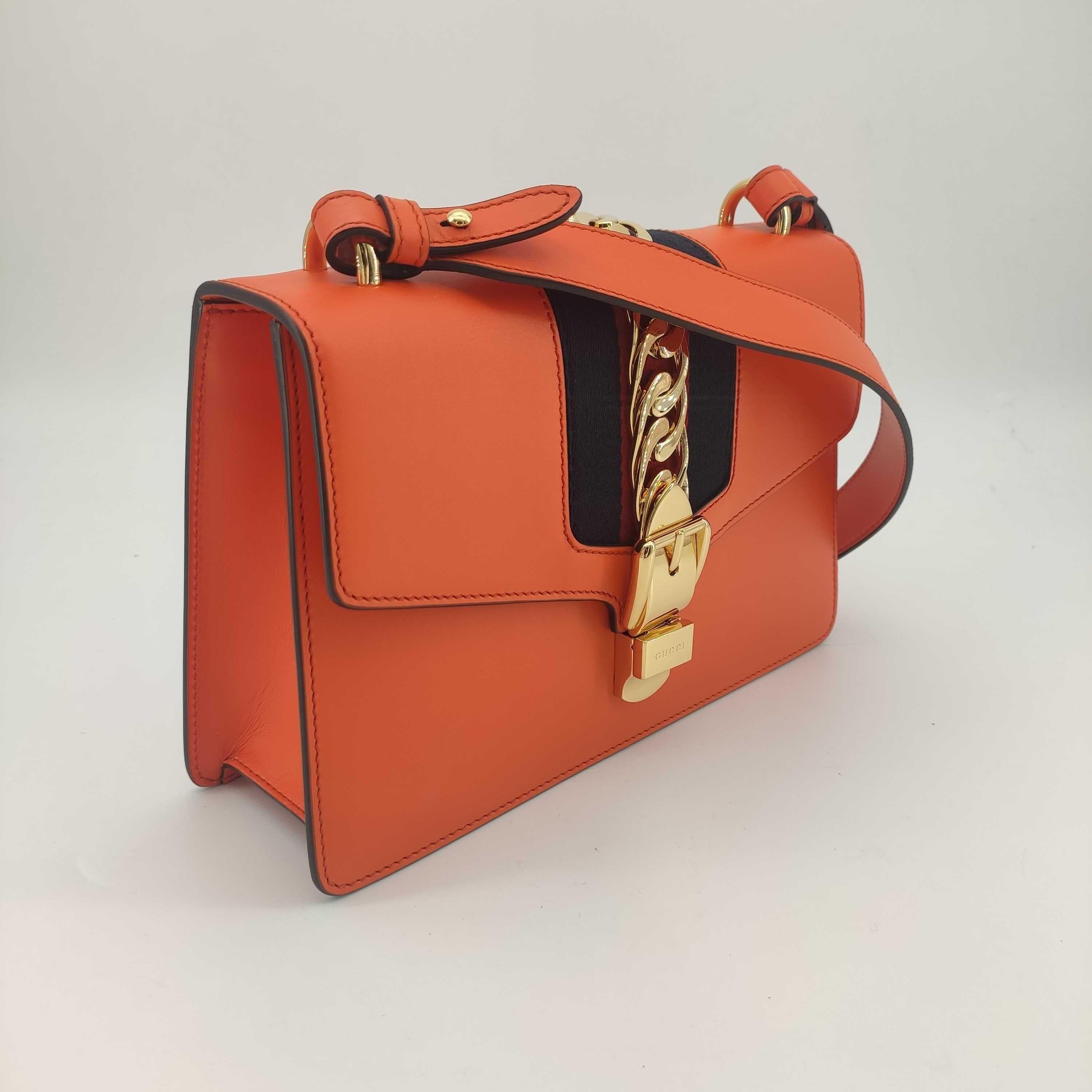 - Designer: GUCCI
- Model: Sylvie
- Condition: Very good condition. Sign of wear on base corners
- Accessories: Dustbag
- Measurements: Width: 25cm, Height: 17cm, Depth: 8cm, Strap: 73cm
- Exterior Material: Leather
- Exterior Color: Orange
-