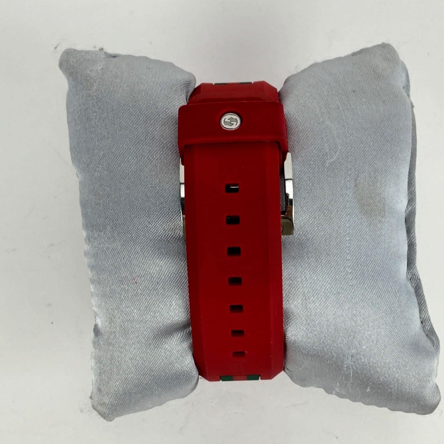 Gucci Sync XXL Unisex Watch, mod. 137.1, in red color. Stainless steel and nylon case (46 mm). Red dial with GG - GUCCI logo. Date at 3 o'clock. Sapphire crystal. Swiss Made Quartz movement. Gucci written on face. Gucci logo on the reverse of the