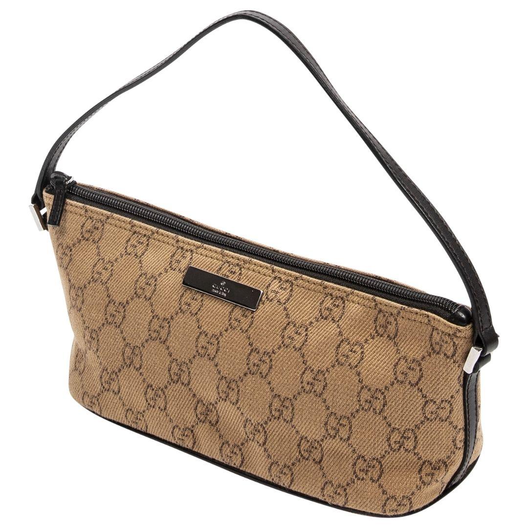 CLASSIC BEAUTY! This is SUCH a cutie crafted in gorgeous beige GG monogram denim canvas with silver-tone hardware, brown leather trimming, and a flat handle! The zipper at the top opens up to a nylon lining. What we love about this piece is the