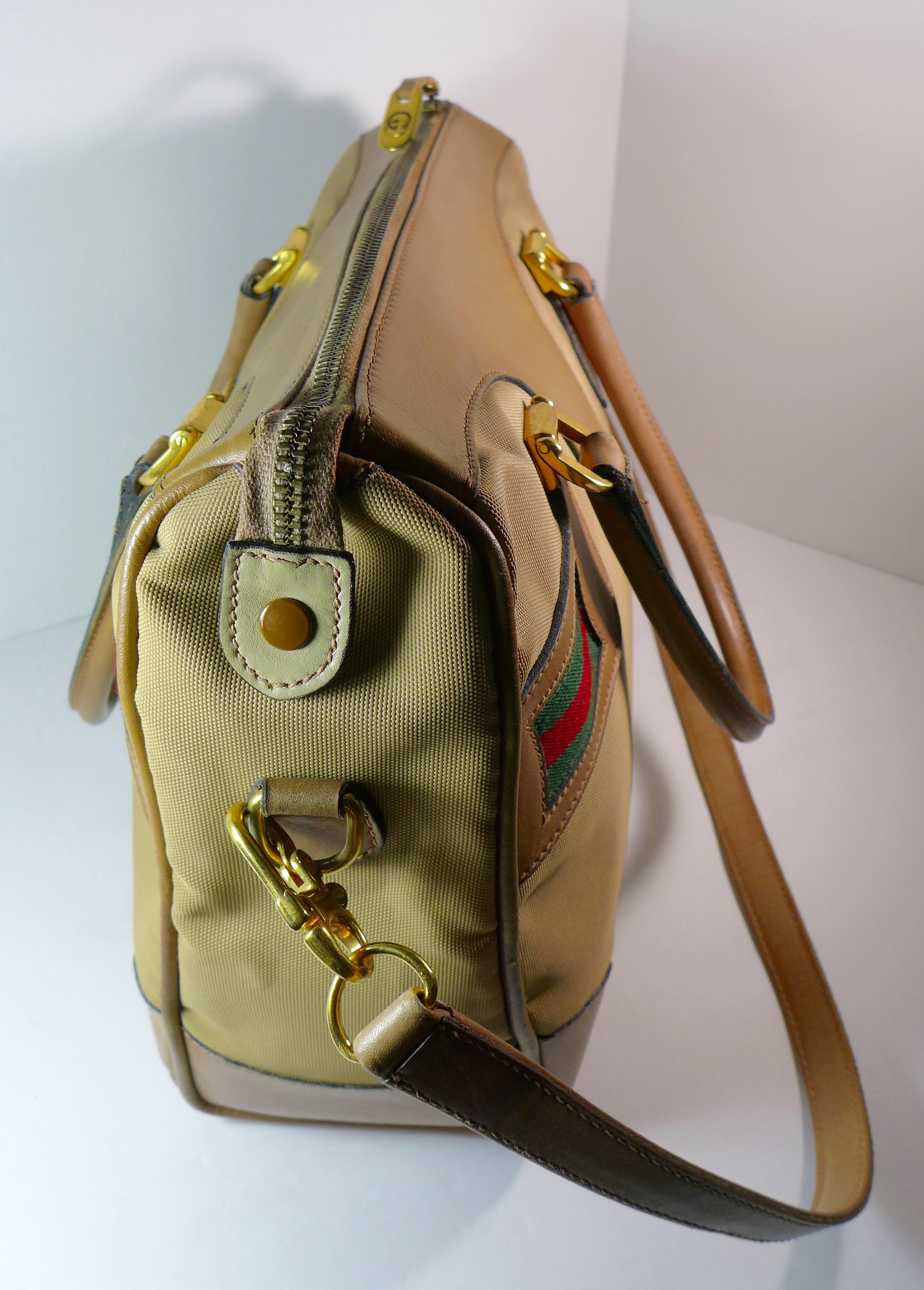 This spacious Gucci tan leather and canvas bag features a leather shoulder strap, leather handles, gold hardware, and the iconic green and red stripes. The bag has a zipper closure and inside zip pocket. 

Measurements in Inches: 
Height: 11
Length: