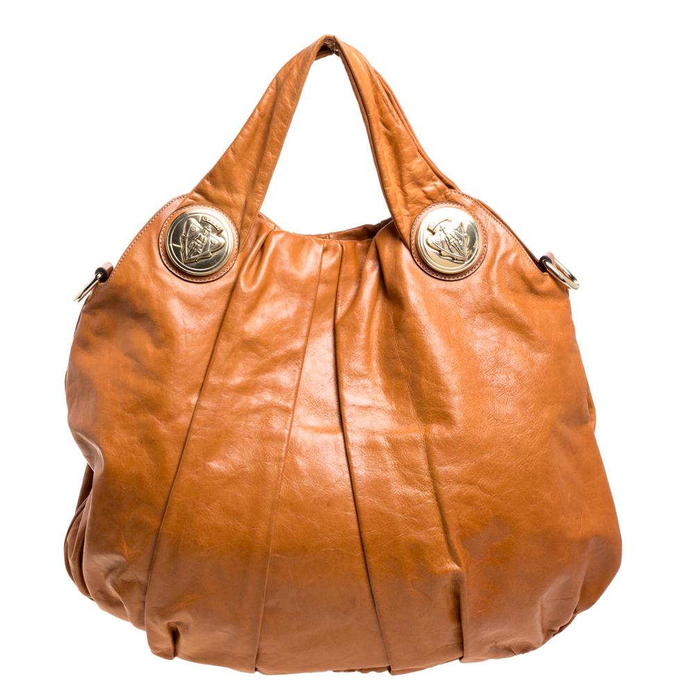 This Gucci hobo is built for everyday use. Crafted from leather, it has a tan-hued exterior adorned with a beautiful tattoo print on the front and two handles for you to easily parade it. The canvas insides are sized well and the hobo is complete