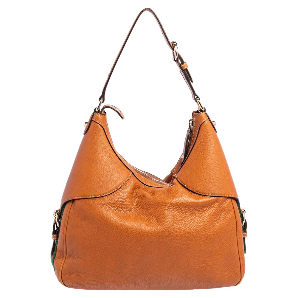 Complete an elegant look with this beautiful Gucci Heritage Horsebit hobo. It is made from leather, and it has the Horsebit accent in gold-tone on the front. The zip closure opens to a canvas-lined interior that will hold your essentials. This bag