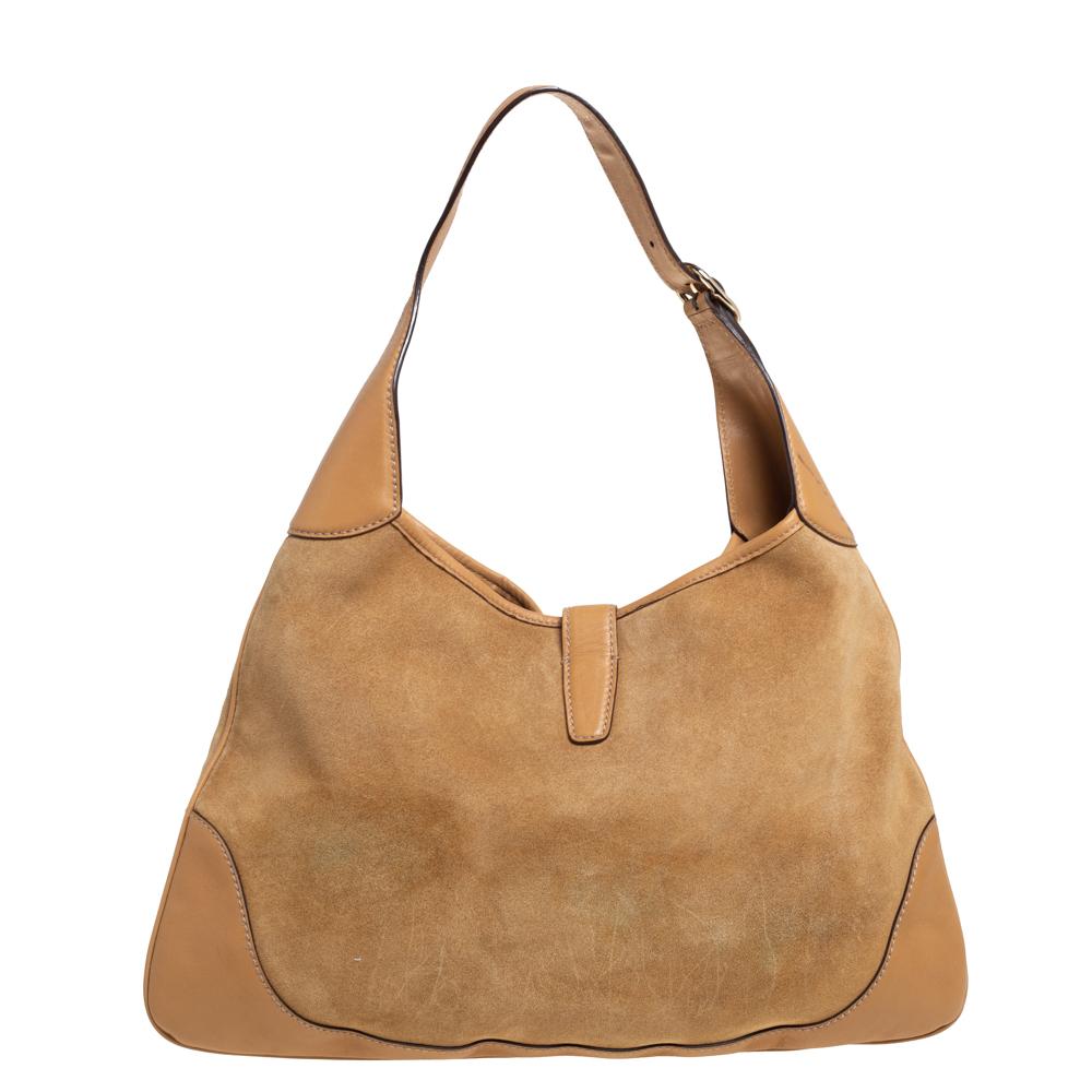 Gucci has always offered a bevy of cult-favorite bags, just like this Jackie O hobo created as a homage to Jacqueline Kennedy Onassis. It is crafted from suede and leather in a tan shade and flaunts grommets detailed on the front. A piston push-lock