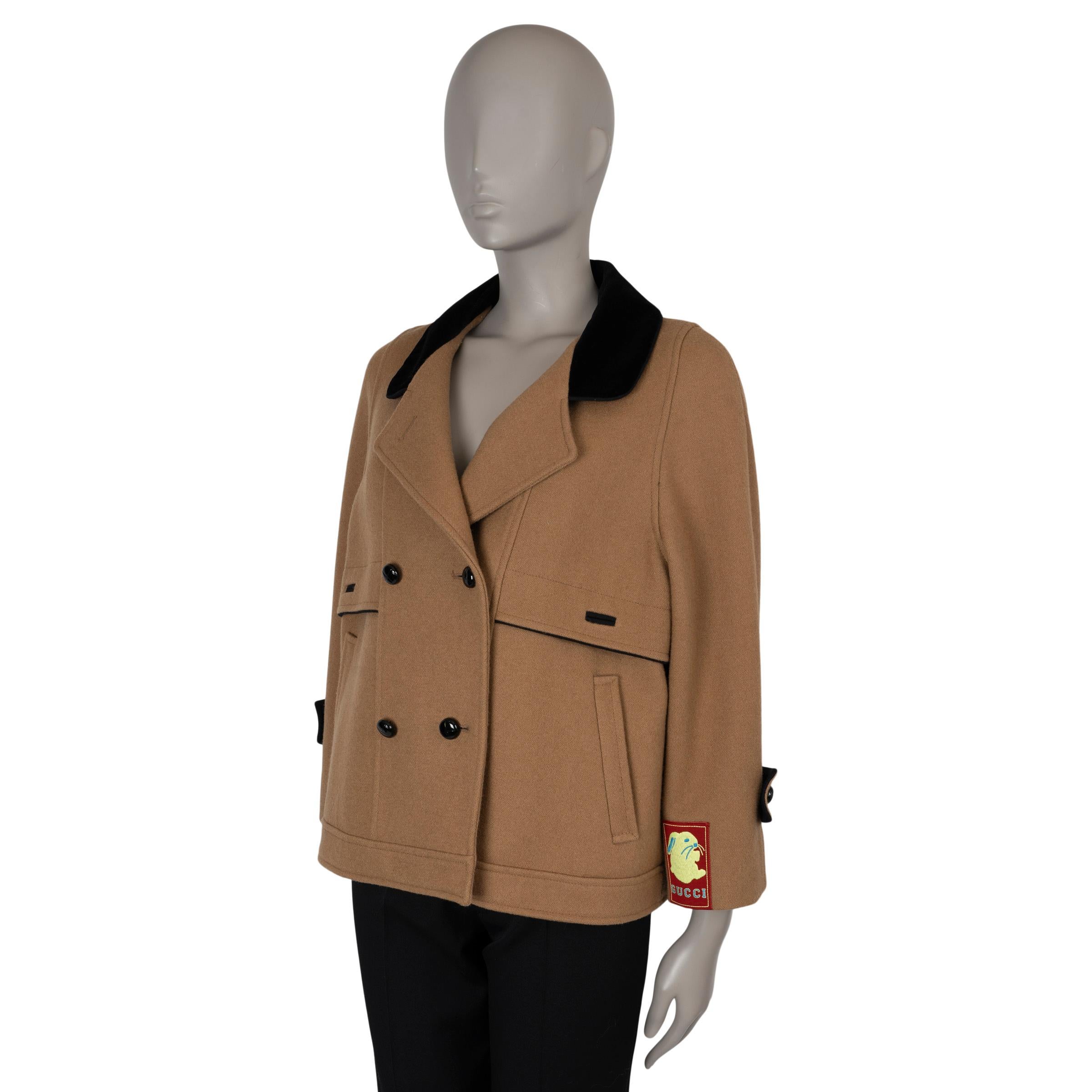 This 100% authentic Gucci peacoat in camel wool (100%) combines timeless style with unique detailing. It features a short, oversized silhouette with notched lapels trimmed in black velvet, adding a touch of contrast. The coat includes two welt