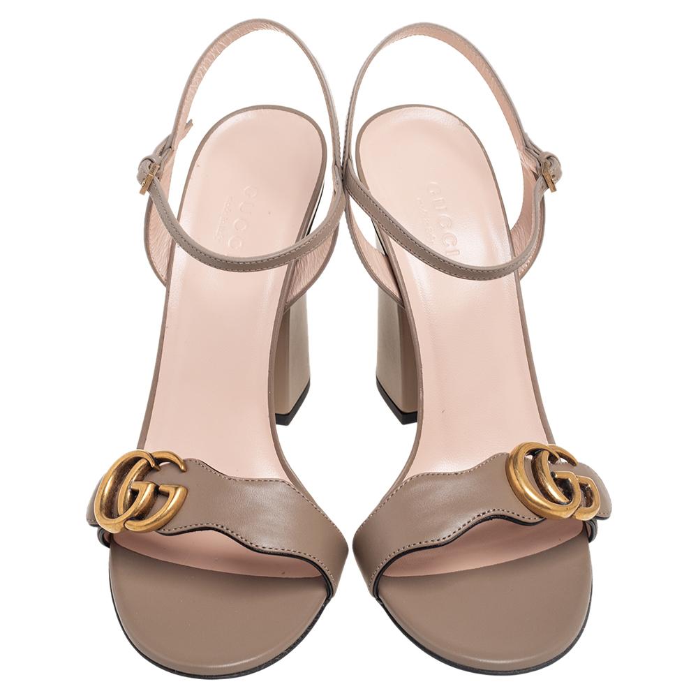 Graceful and chic at the same time, these GG Marmont sandals from Gucci are simply amazing! They have been crafted from taupe leather on the exterior, with a gold-toned GG motif perched on the frontal strap. These sandals are designed with a buckled