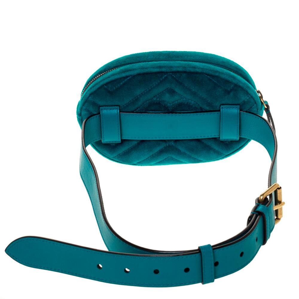 The Gucci Marmont bag has been exquisitely crafted in Italy and made from teal-hued velvet featuring the signature Matelasse pattern all over. It is equipped with a luxurious satin interior that is secured with zip closure. On the front, there is