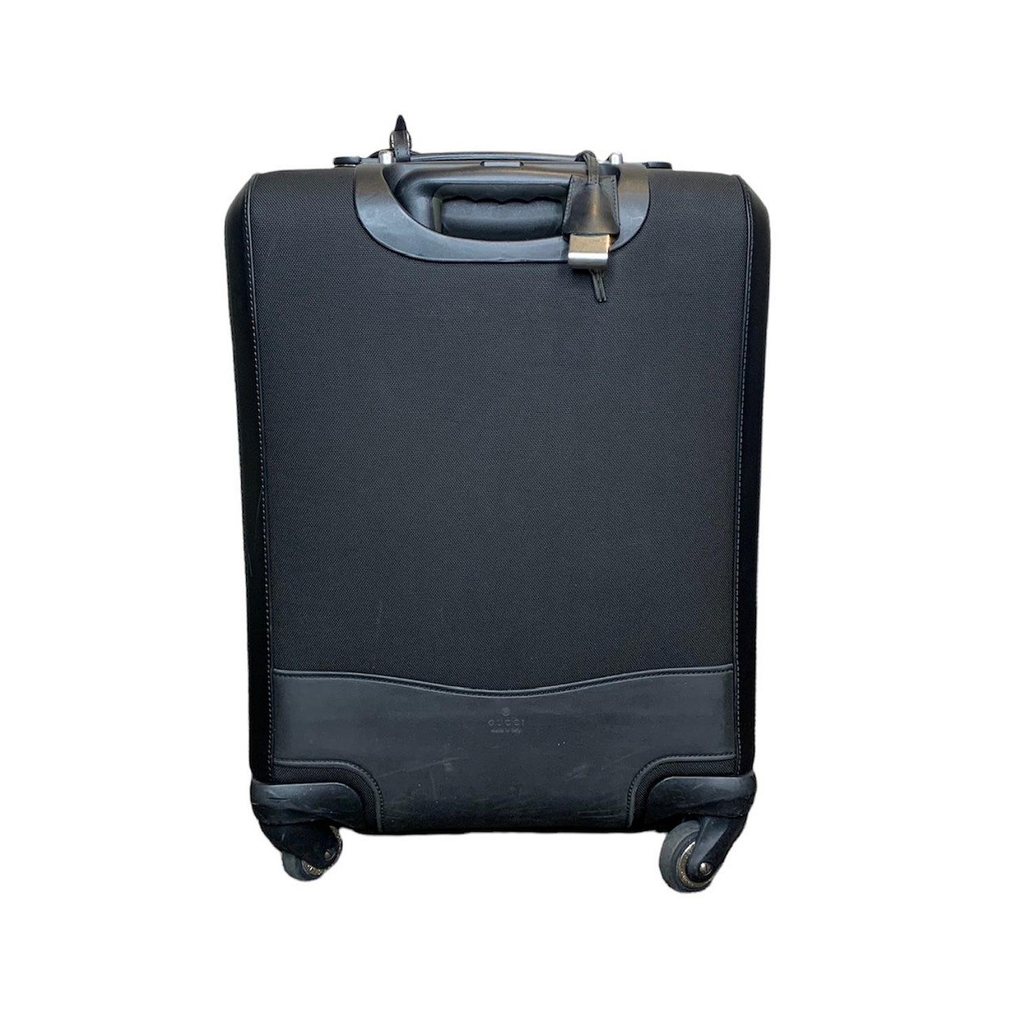 Wheeled carry-on in a techno fabric with red and green web detail.

Designer: Gucci
Material: Black techno fabric with black leather detail
Origin: Italy
Date/Authenticity Code: 368778.200047
Interior Lining: Black nylon
Measurements: 14.9
