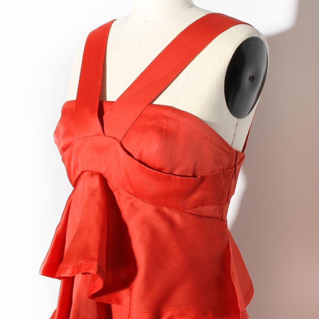 Gucci by Frida Giannini Dress
Made in Italy 
Produced in 2006 
Red 
Halter neckline 
Empire waistline 
Babydoll style silhouette 
Tier of ruffles down dress 
Dress has a structured corset lining with boning 
Invisible zipper down left side of dress