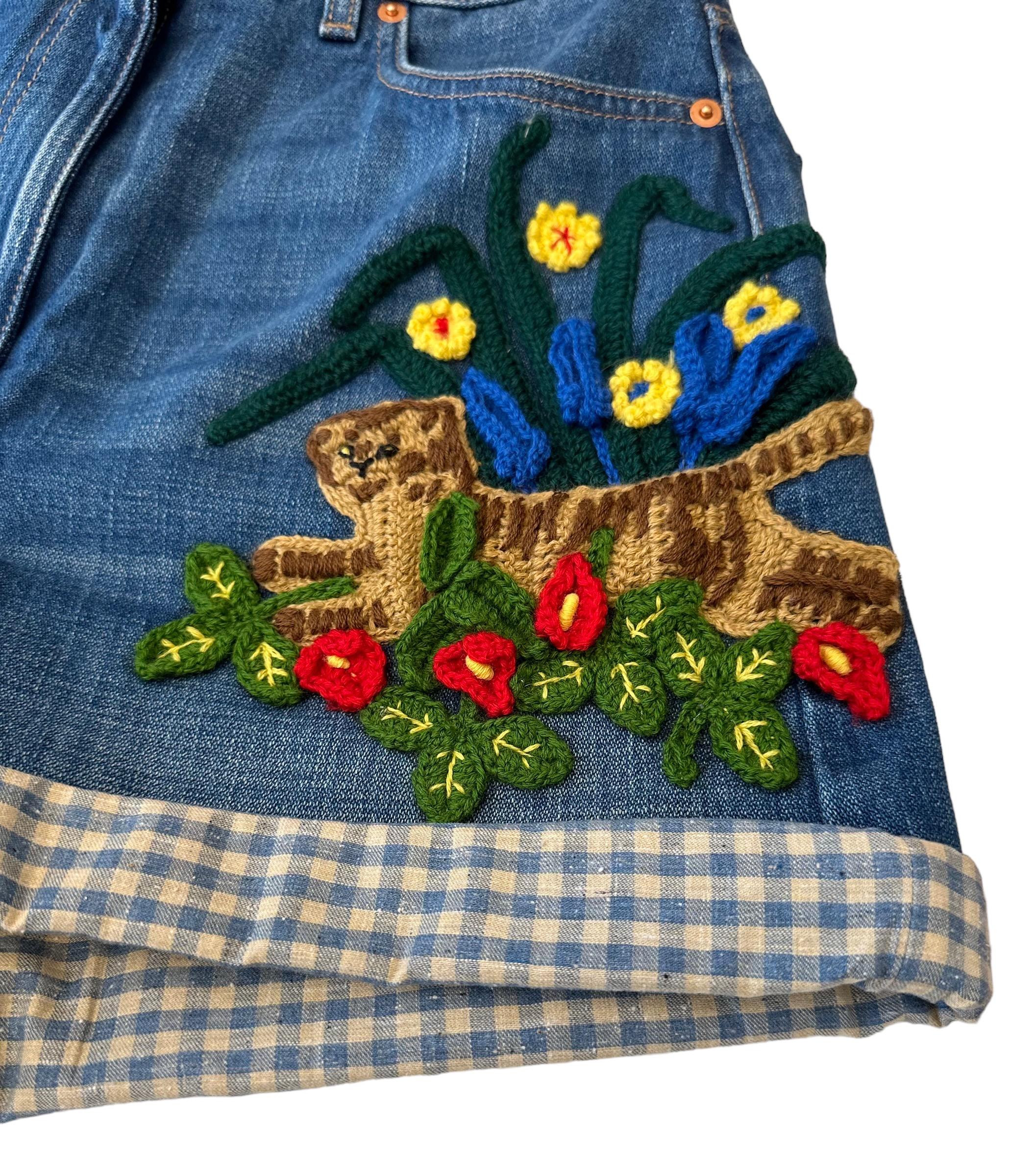 This pre-owned pair of denim shorts from the house of Gucci is a five pockets style. It is high waisted with a zip and button closure.
It features a Tiger and flower embroidery in the front and a metallic Gucci vintage logo label at the