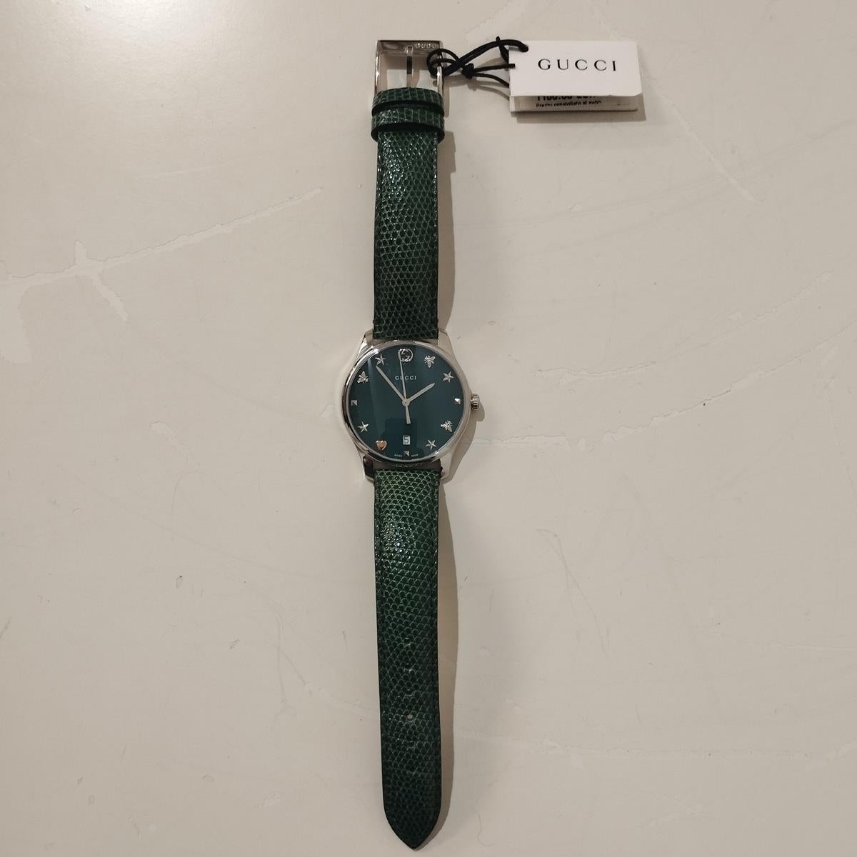 Belle montre Gucci neuve et de grande qualité
Montre intemporelle
YA126585
Acier 
Cadran en nacre verte
Verre
Mécanisme à quartz (pile neuve)
Résistant à l'eau
Boîtier 29 mm
Bracelet en cuir imprimé lézard vert 
Avec boîte
Prix original €