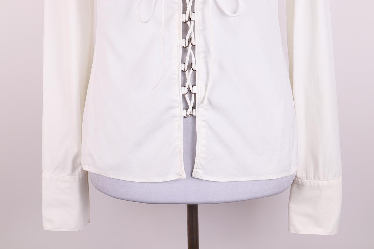 Gucci Tom Ford 2002 Hemd

Weißes langärmeliges Hemd mit Schnürung
Bei dem abgebildeten Hemd handelt es sich um eine weiße Bluse oder ein weißes Hemd mit langen Ärmeln und einer geschnürten Vorderseite. Dieses Detail ermöglicht einen verstellbaren