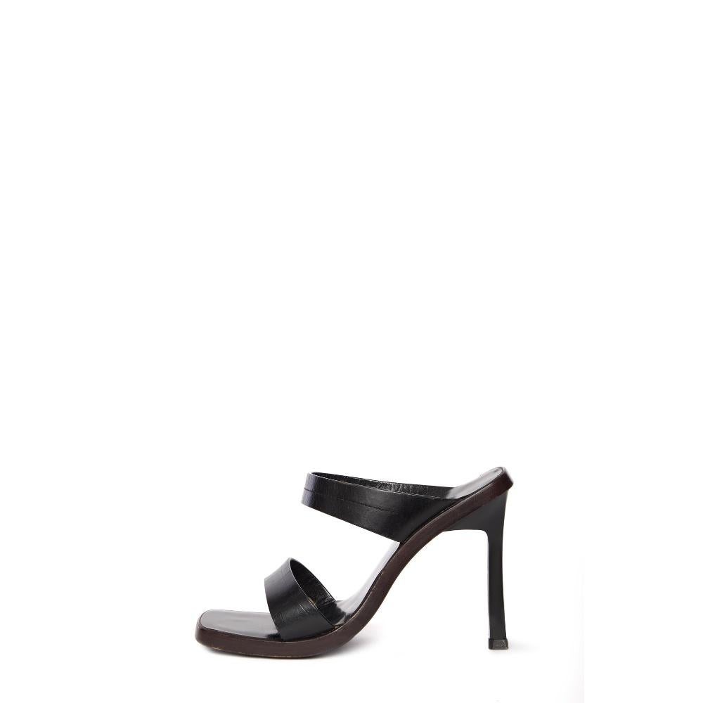 These iconic Gucci mules, designed by Tom Ford, offer a sleek and sophisticated look that blends timeless elegance with modern appeal. Crafted from smooth black material, these open-toe mules are designed with minimalist straps and a sculpted heel,