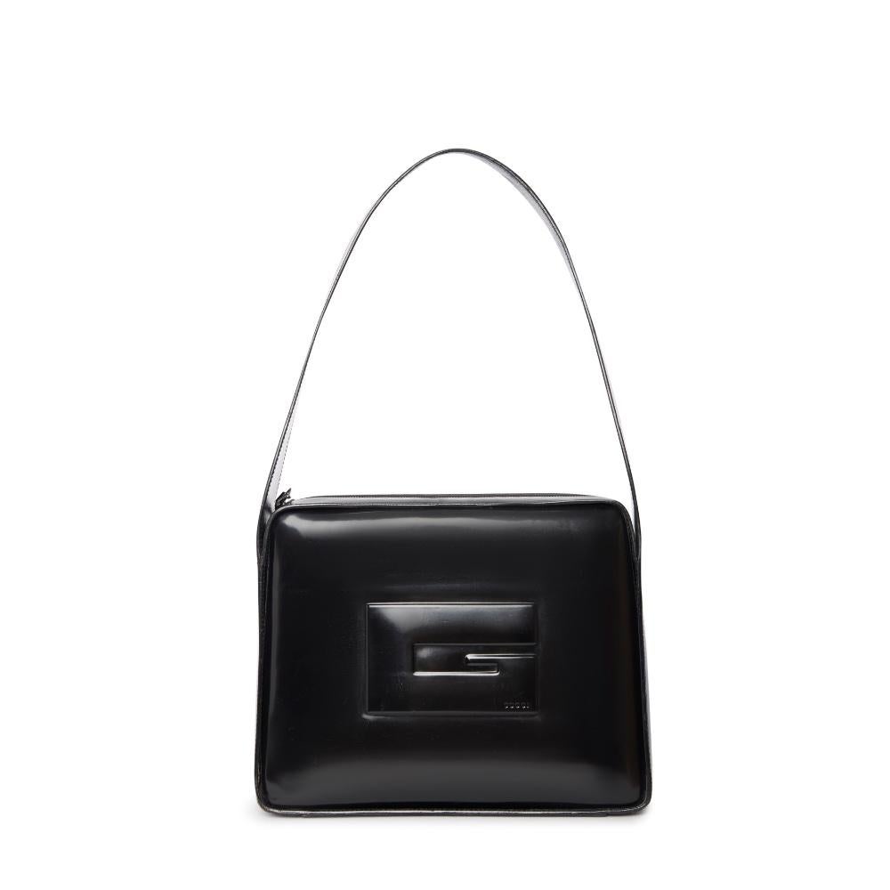 Step into luxury with this sleek, vintage Gucci leather bag from the Tom Ford era. This iconic piece, crafted from high-quality black leather, is designed with a signature geometric 