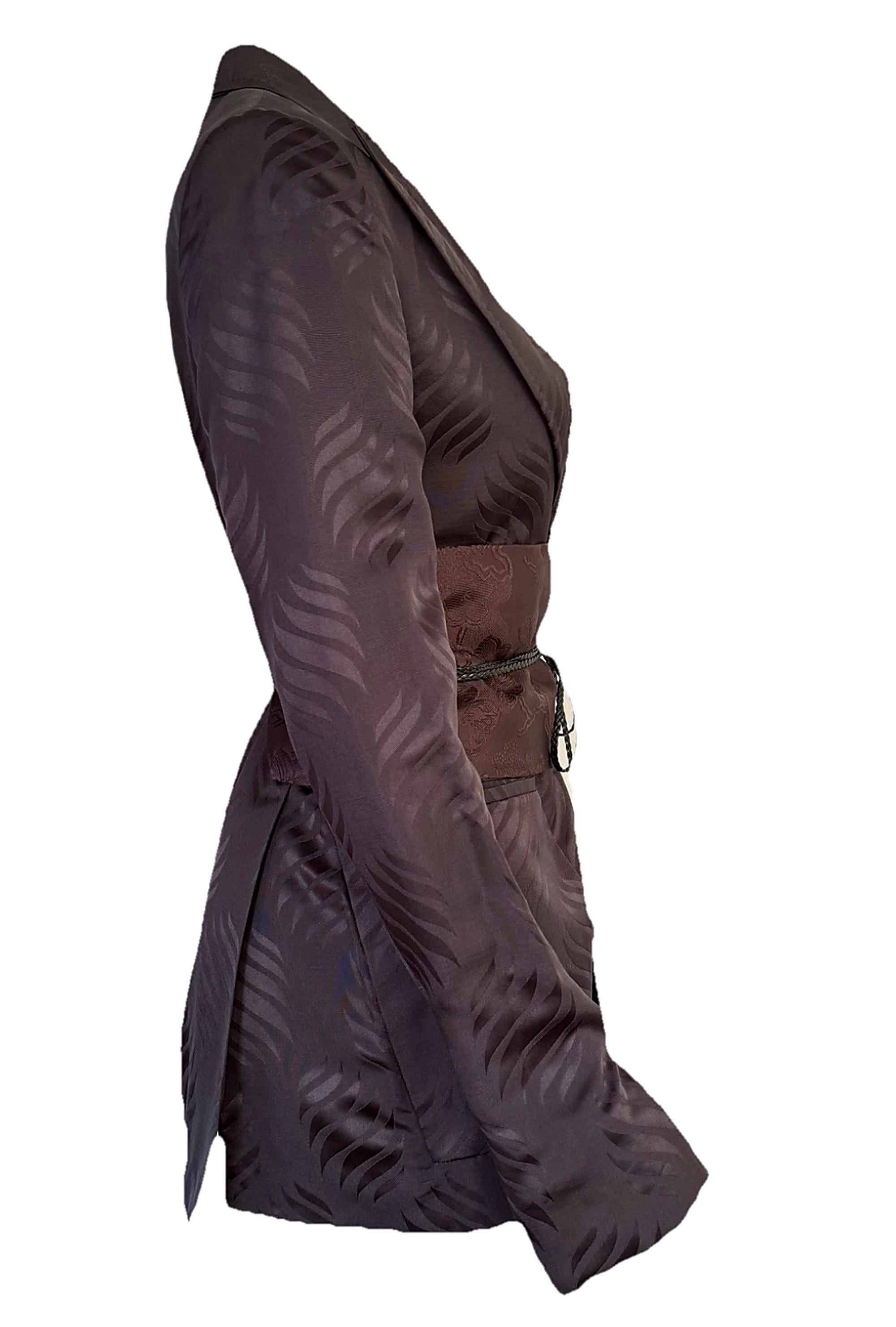 Uno splendido ensemble d'archivio della leggendaria collezione Gucci Autunno/Inverno 2002 di Tom Ford, in cui convergono il glamour hollywoodiano, il rock 'n' roll e i motivi giapponesi. Presentato nella campagna pubblicitaria della stagione