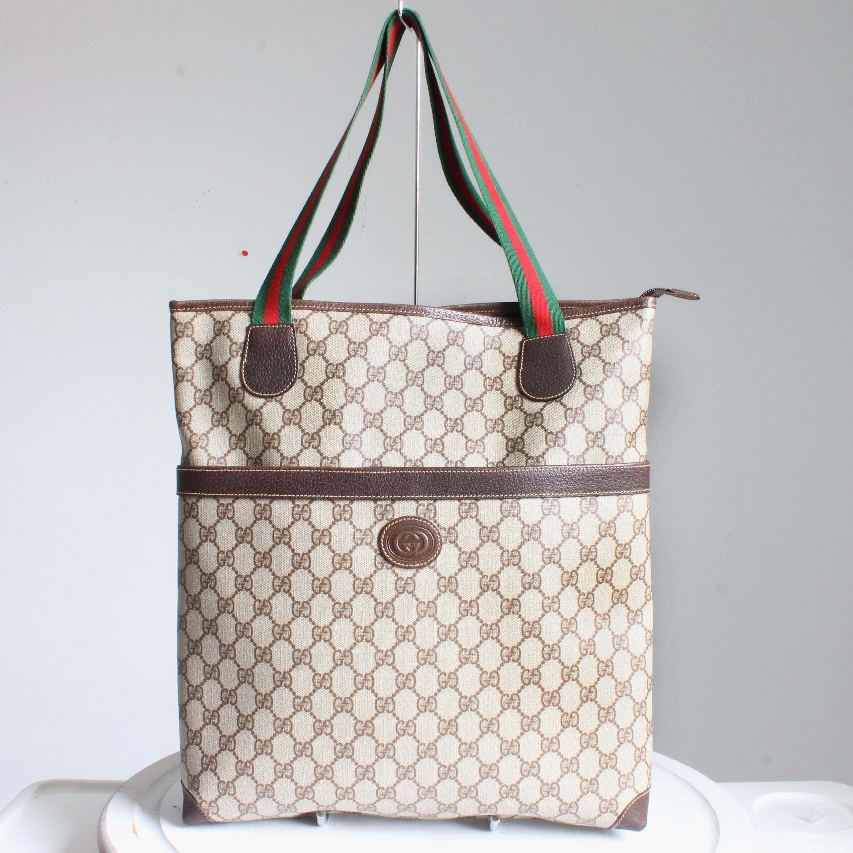 Authentic, preowned, vintage Gucci GG Plus Web tote, likely made in the 80s.  Made from Gucci's GG canvas, it's trimmed in brown leather and features Gucci's signature webbing on the straps, with a large magnetic snap pocket in front.  The interior