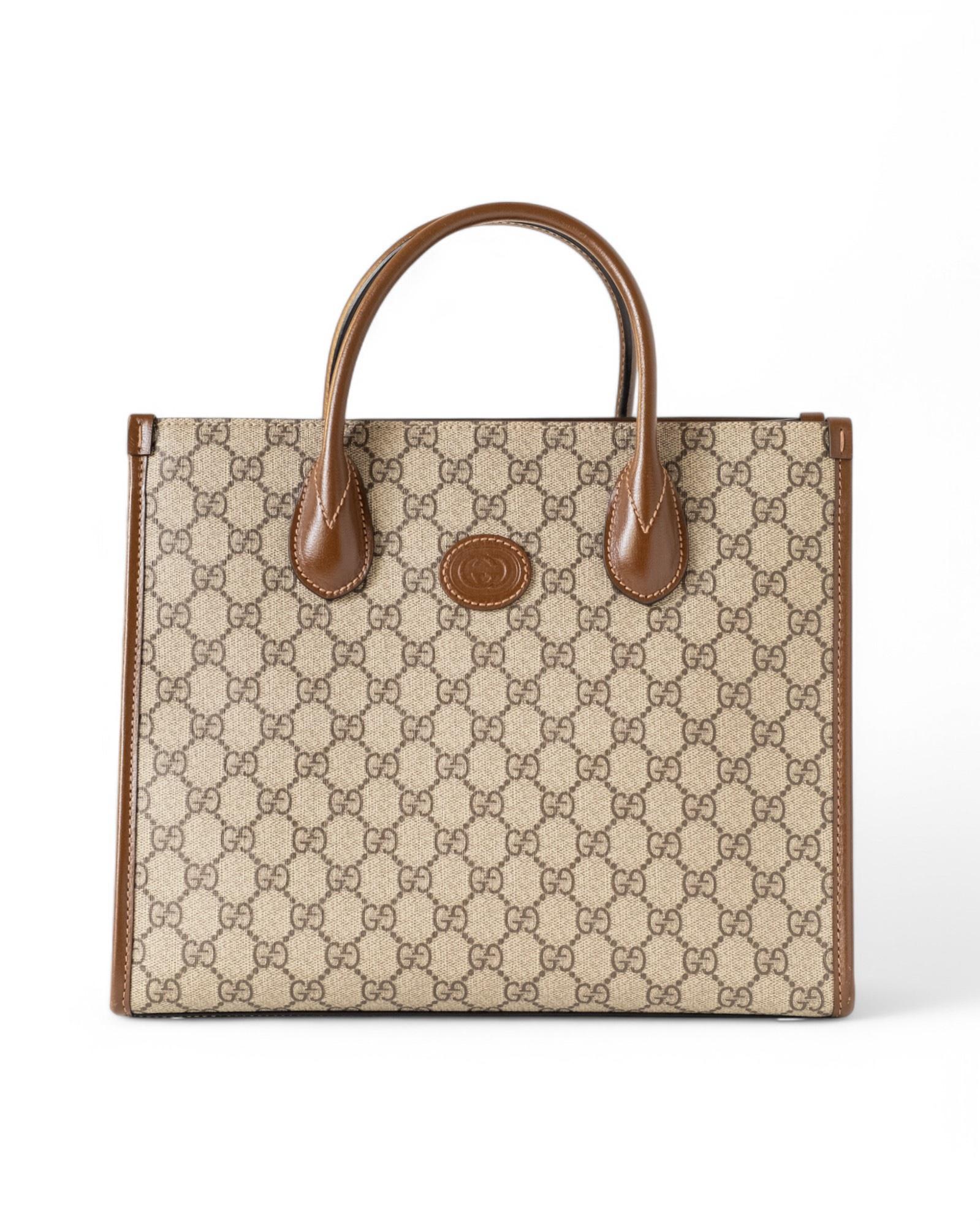 Gucci's signature Tote Bag in the small size, made of canvas in the classic GG Supreme pattern with leather inserts and gold hardware. Equipped with a hook-and-eye top closure, internally lined with beige canvas with convenient pocket, quite roomy.