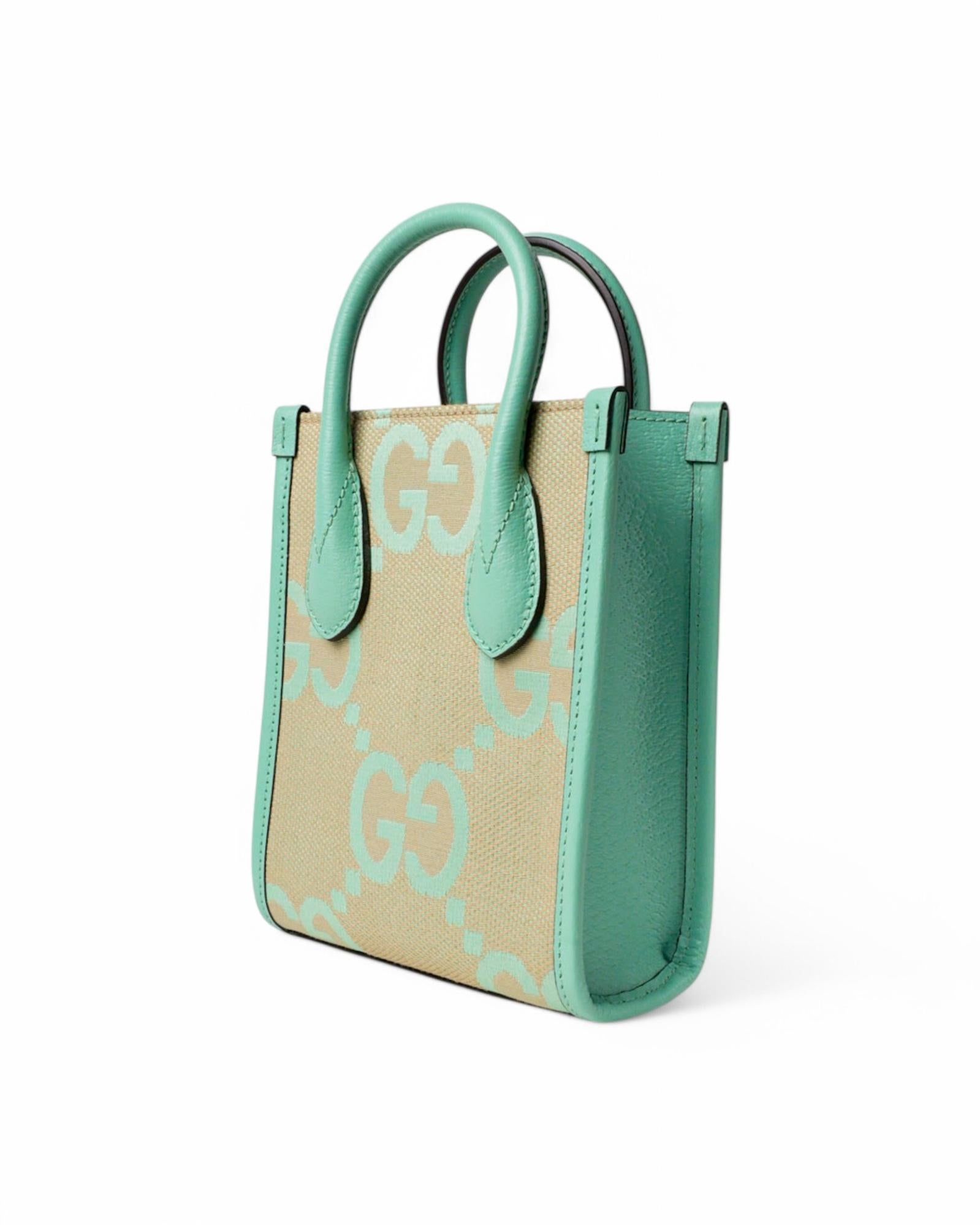 Signature Gucci bag, Tote Mini model, made of canvas in the GG Jumbo pattern with green leather inserts and gold hardware. Has no top closure, internally lined in beige canvas with small leather pocket, roomy for essentials. Equipped with double