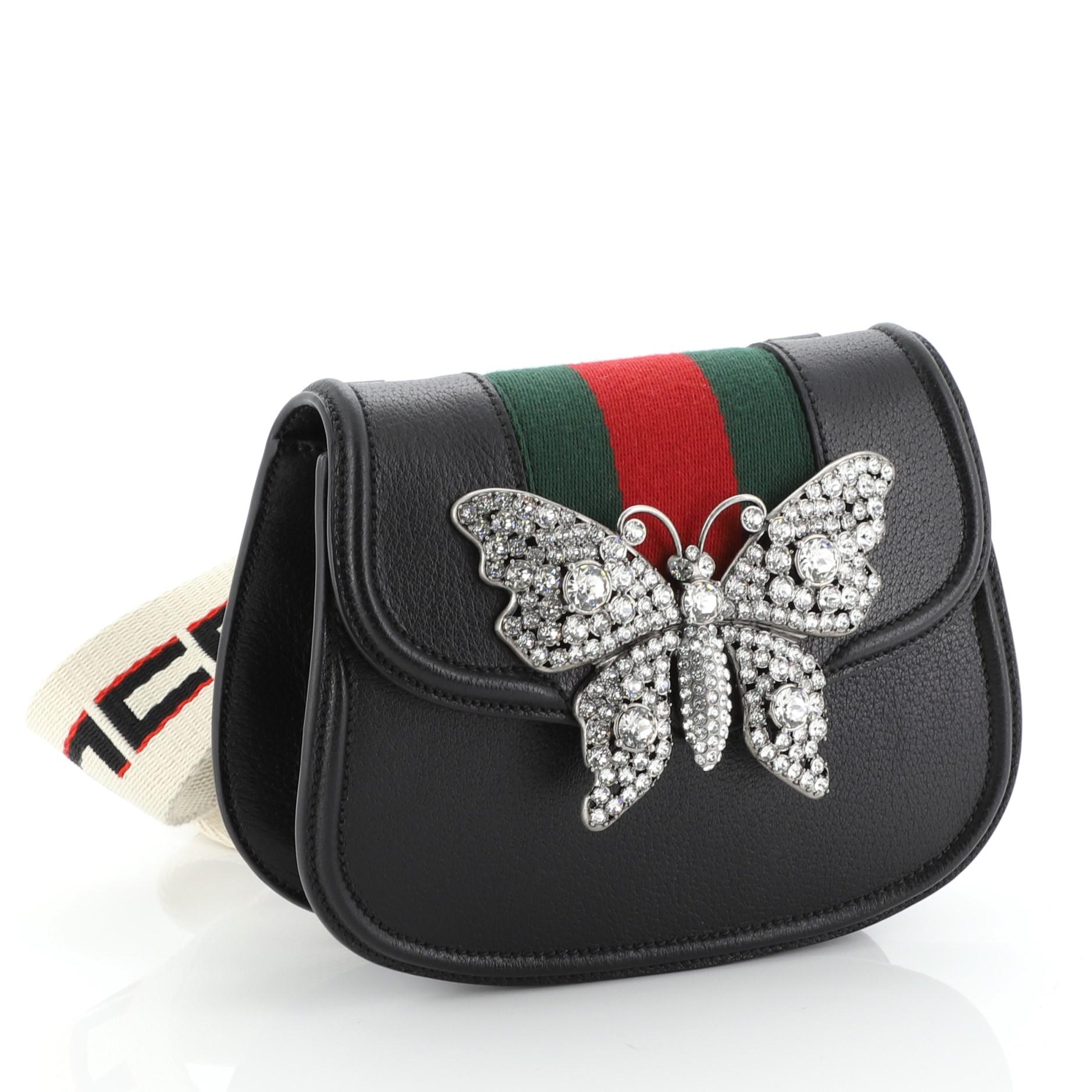 This Gucci Totem Shoulder Bag Leather Small, crafted in black leather, features a detachable shoulder strap, front flap with enameled metal butterfly ornament, web detailing and aged gold and silver-tone hardware. Its magnetic closure opens to a
