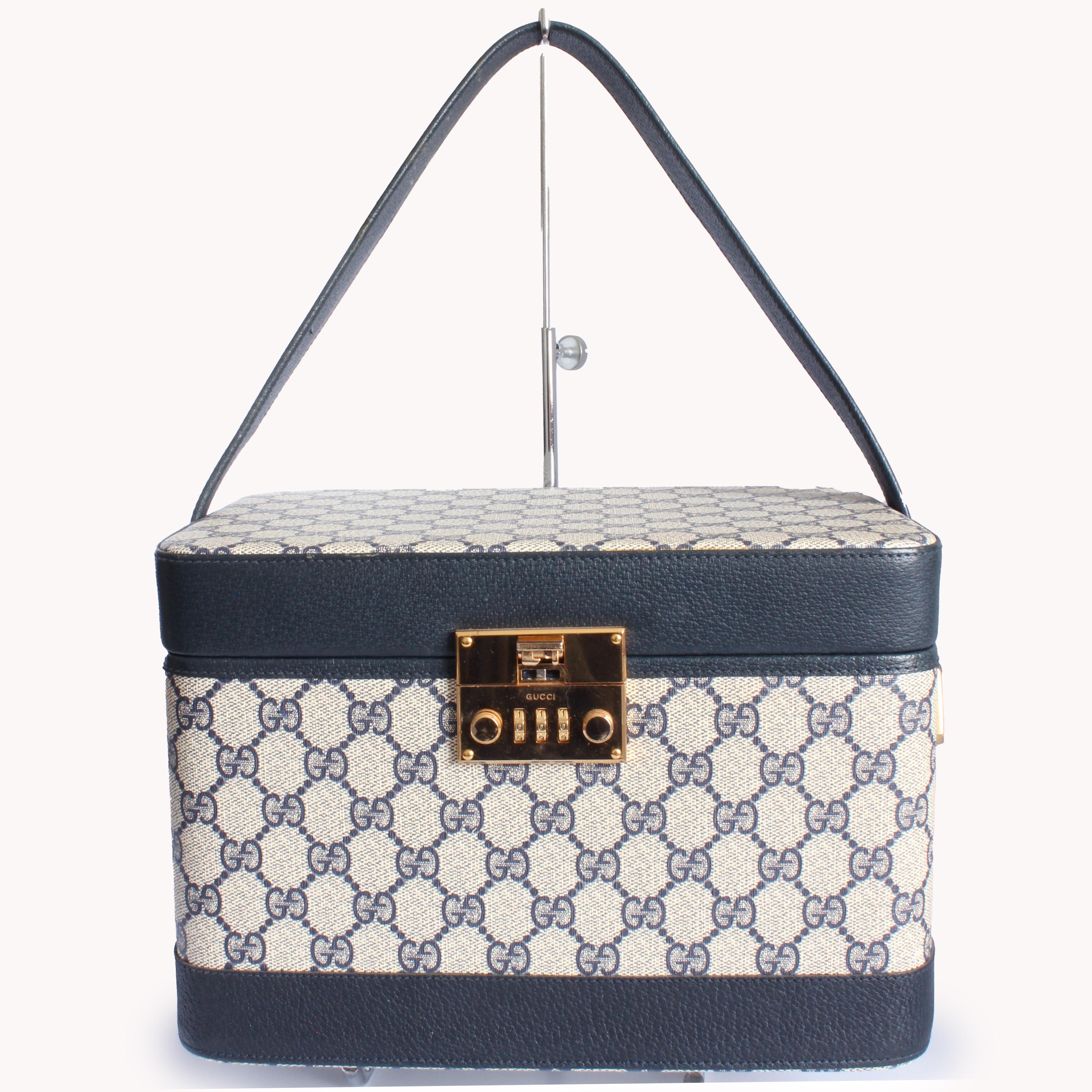 Travel in style with this incredible vintage train case made by GUCCI, most likely in the 1980s.  Made from their signature GG logo canvas, it's trimmed in navy leather and has gold hardware.  The interior is lined in navy leather and features a