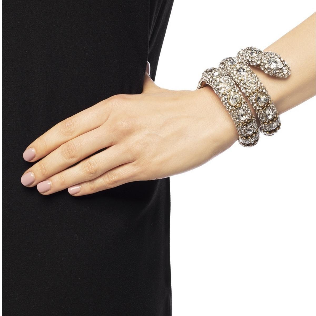 This gold-plated Gucci snake wrap bracelet is crafted with metal in Italy and shaped after a snake that wraps around the wrist. Decorated with white  crystals, this piece has a flexible construction for an adjustable fit. 
Composition: Gold Plated