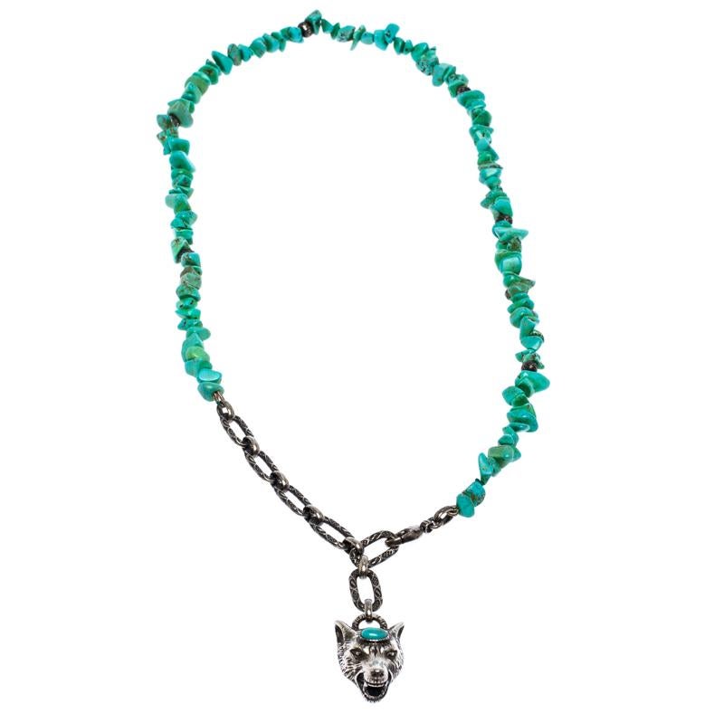 C'est vraiment une joie de voir ce collier Gucci. Magnifiquement conçu en métal argenté, ce collier est composé d'un cordon en soie rehaussé de howlite teintée et d'un pendentif en forme de tête de loup. Le collier est complété par un fermoir en