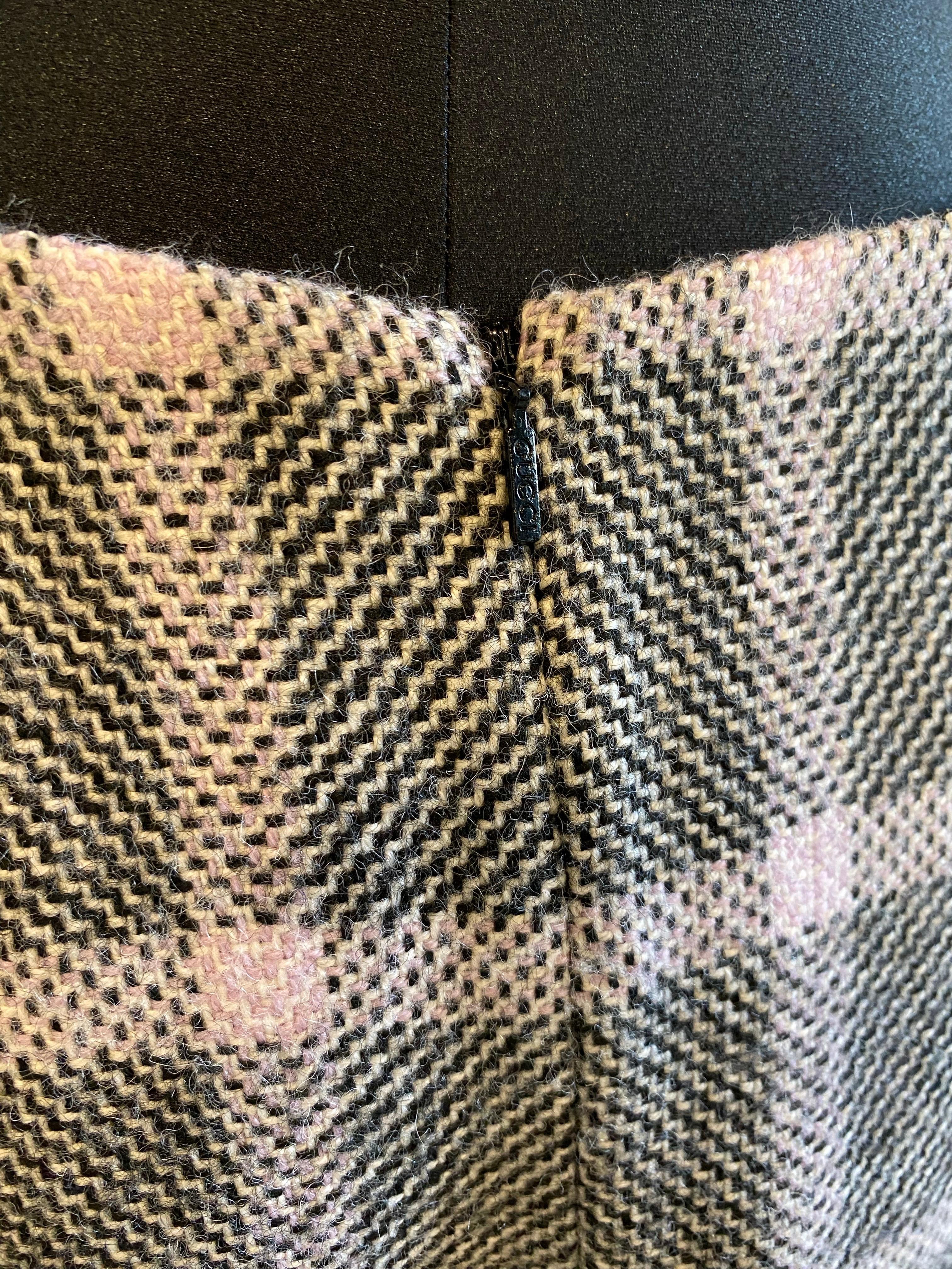 Gucci Tweed skirt in shades of black that looks almost gray and pink lilac with a check pattern.
There is no composition label but certainly 100% wool.
Size 40.
Back zip closure and back slit.
Waist 40 cm
Hips 50 cm
80 cm long