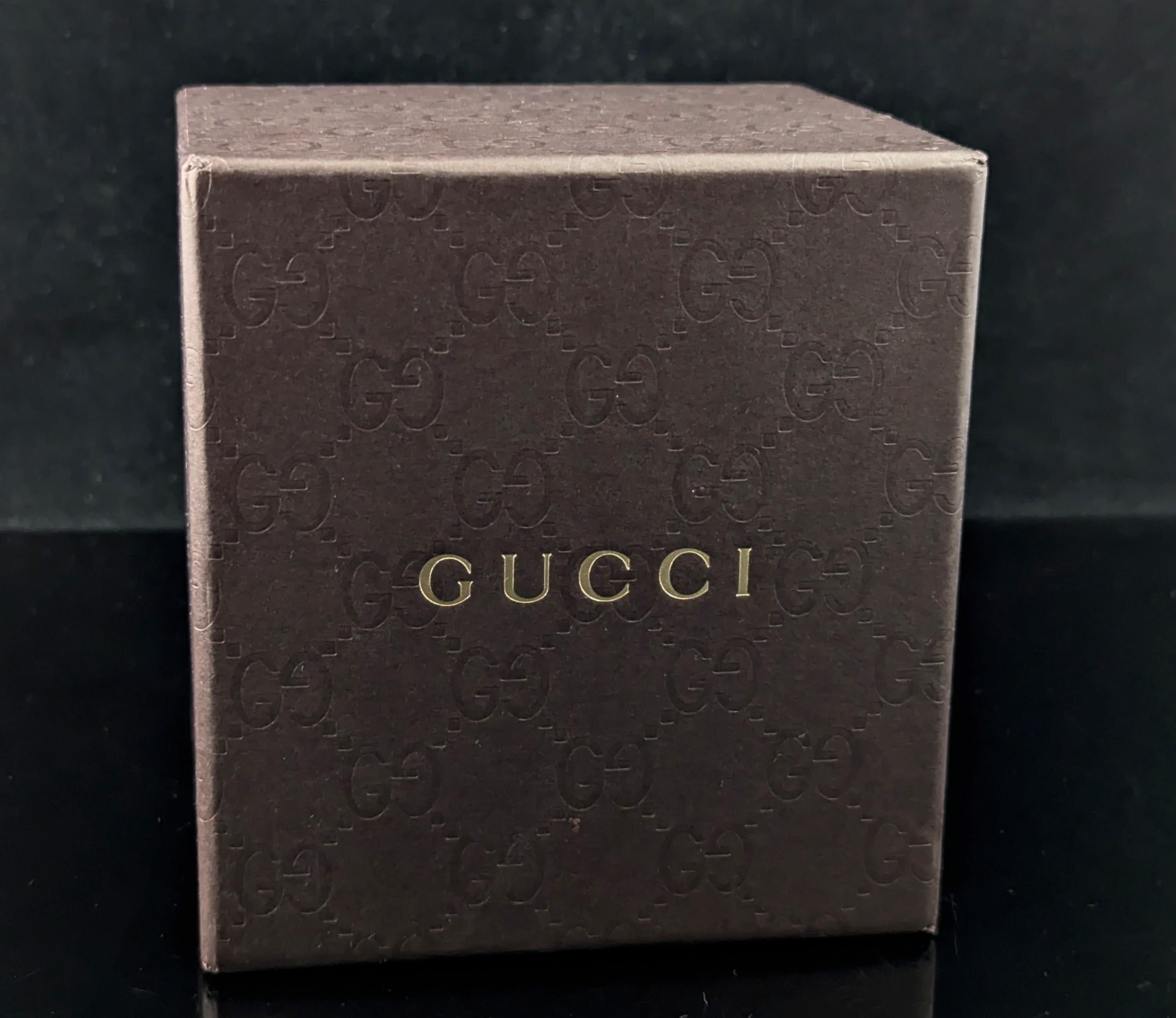 Montre-bracelet Gucci Twirl pour femme, élégante et emblématique, en acier inoxydable de couleur argentée.

Il s'agit d'une montre à bracelet avec un design découpé et un cadran central virevoltant.

Le boîtier est en acier inoxydable avec un cadran