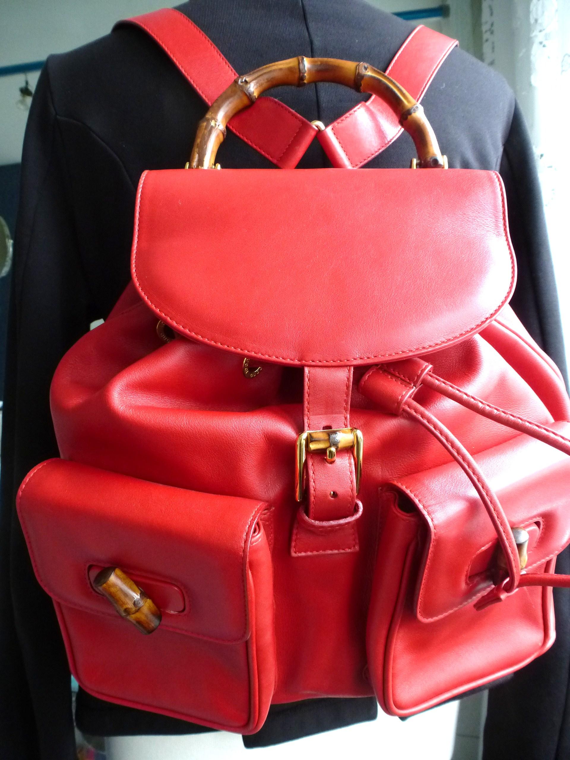 Classic luxury pre loved GUCCI two pocket backpack with iconic bamboo details in red leather. 

Measurement:  Height 30 cm, Width 37 cm around 74 cm, Deep 10 cm, 2 rear straps 80 cm maximal, pockets on the front H 14 cm x 11 cm .
The backpack is in