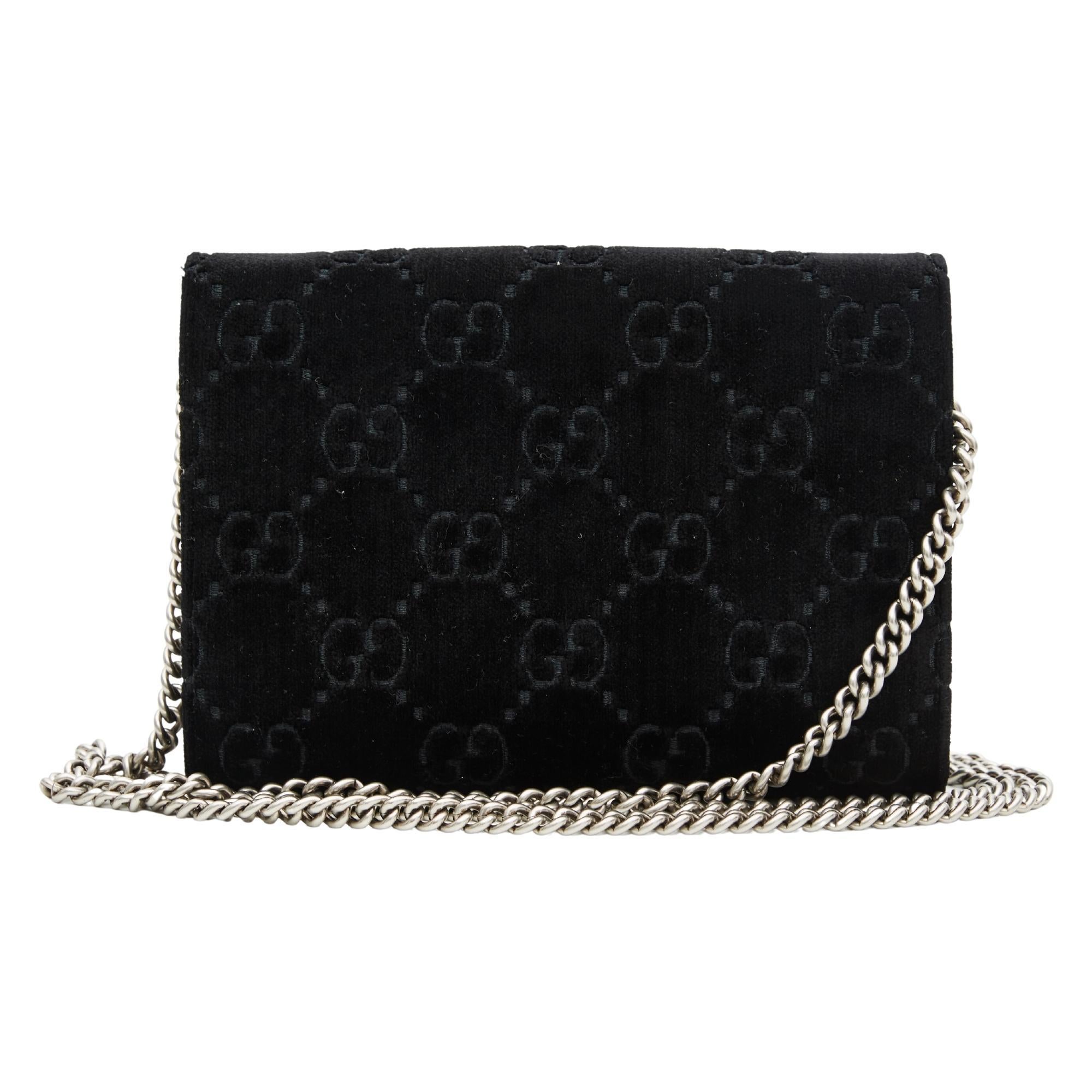 This bag is made of Gucci monogram in black velvet. This bag features an optional silver chain shoulder strap and a textured horseshoe closure with lion heads and crystals. This opens to a black fabric and leather interior with cards slots, patch