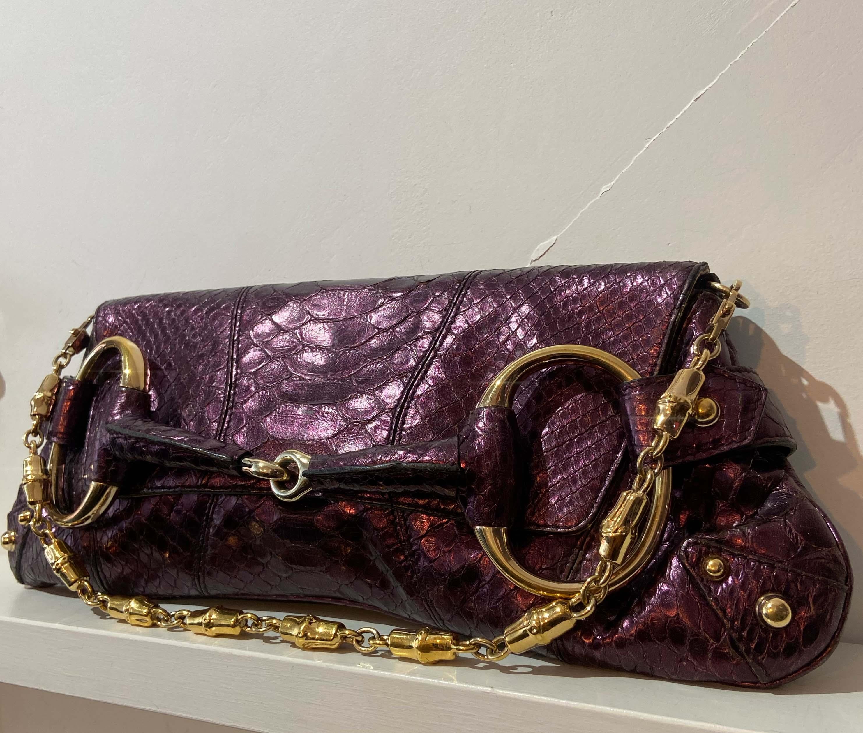  Gucci 1955 metallic purple lizard clutch - collectors item. Features signature horsebit detailing, lizard leather skin, detachable chain strap with Gucci branded magnetic closure and interior pocket. In great vintage condition, some natural