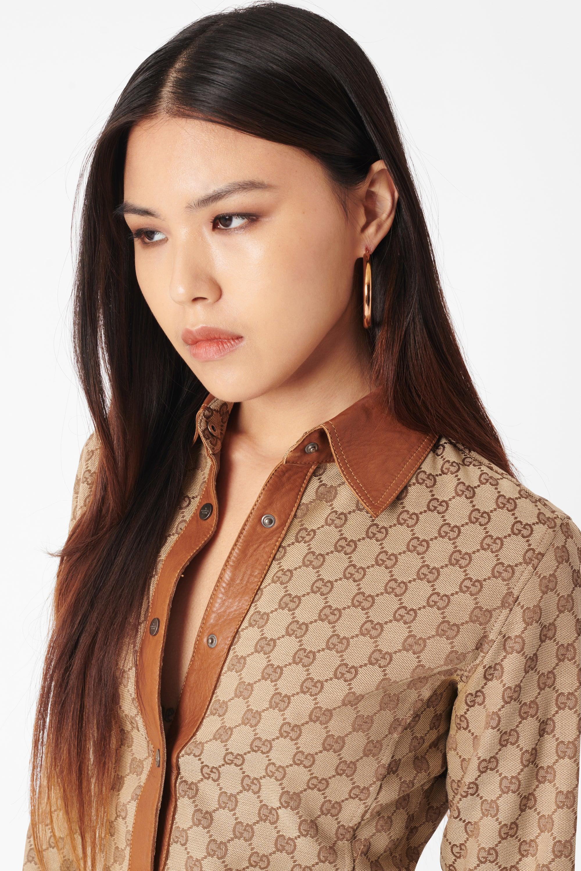 Gucci by Tom Ford 2000 monogram booty short set. Top features ‘Gucci’ pop button closure, monogram body, long sleeves, leather collar and cuffs with contrast stitch detailing. Shorts feature monogram detailing all over with leather waistband in a