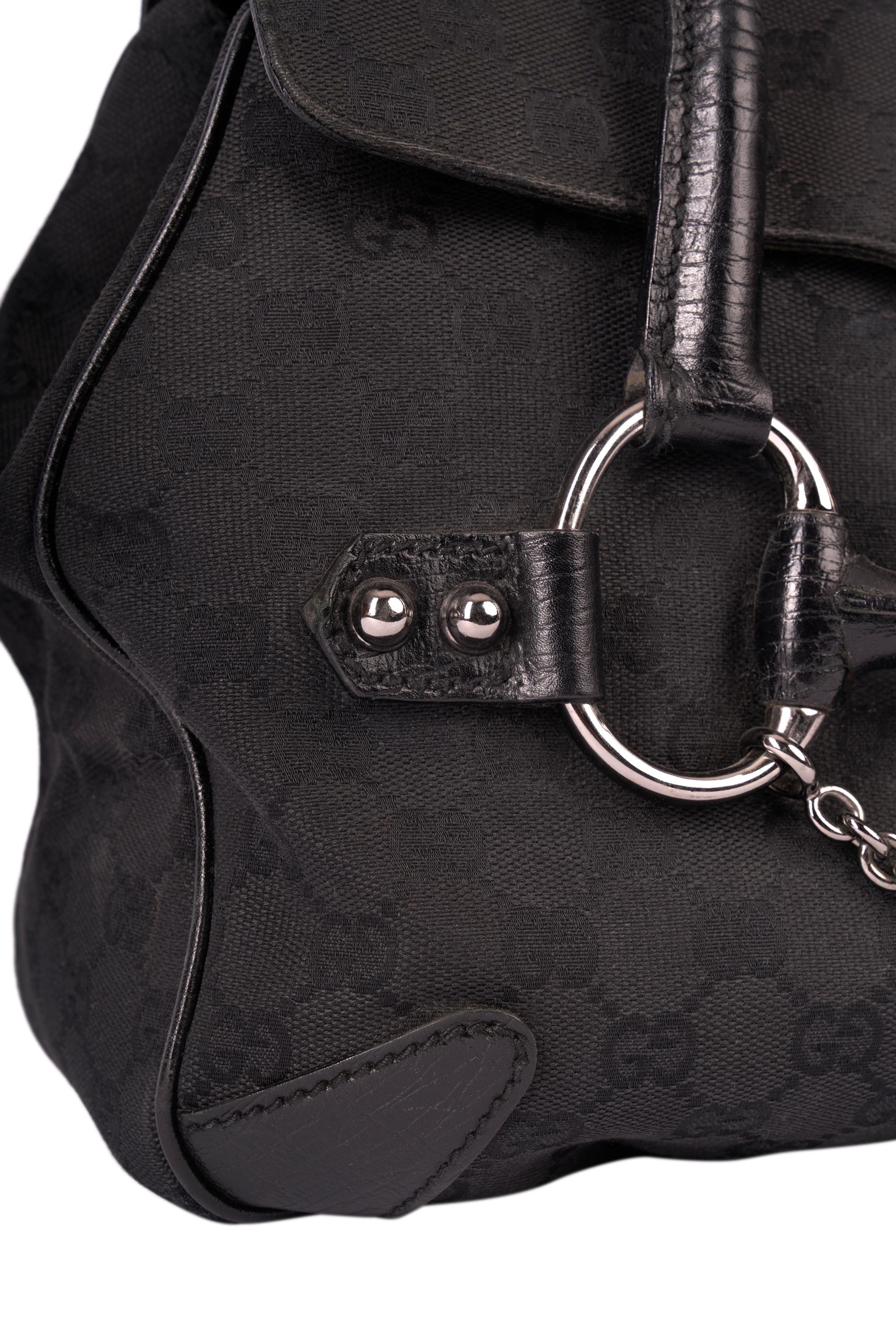 Bolso vintage Gucci Negro Monograma horsebit. Presenta el clásico logotipo Monograma GG negro por todas partes. Cuero negro  mango,  interior con bolsillo con cremallera y forro. La parte delantera del bolso presenta herrajes plateados con forma de