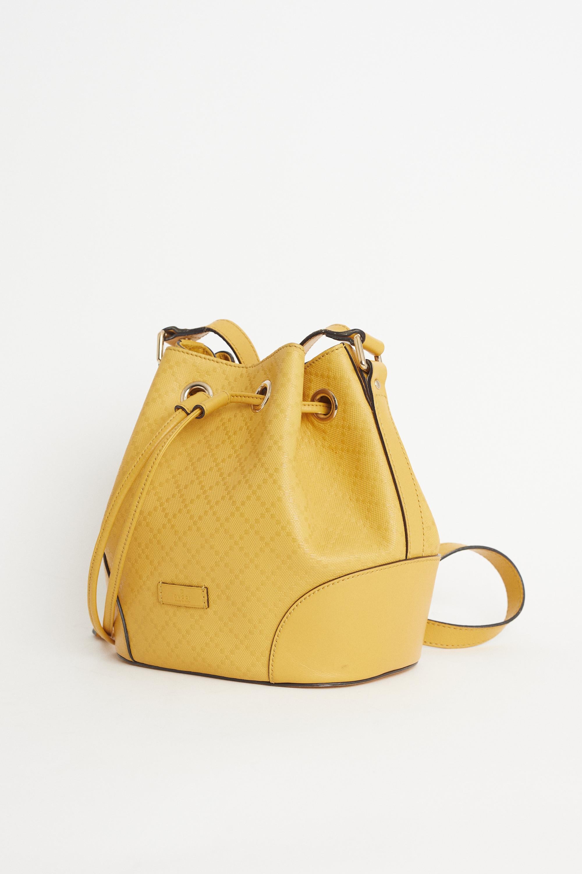 We are very excited to present this Vintage 2000’s Gucci yellow diamante embossed bucket bag. Features an adjustable flat leather shoulder strap, open top with drawstring closure,  interior zip and slip pockets. Pre-loved, in excellent vintage