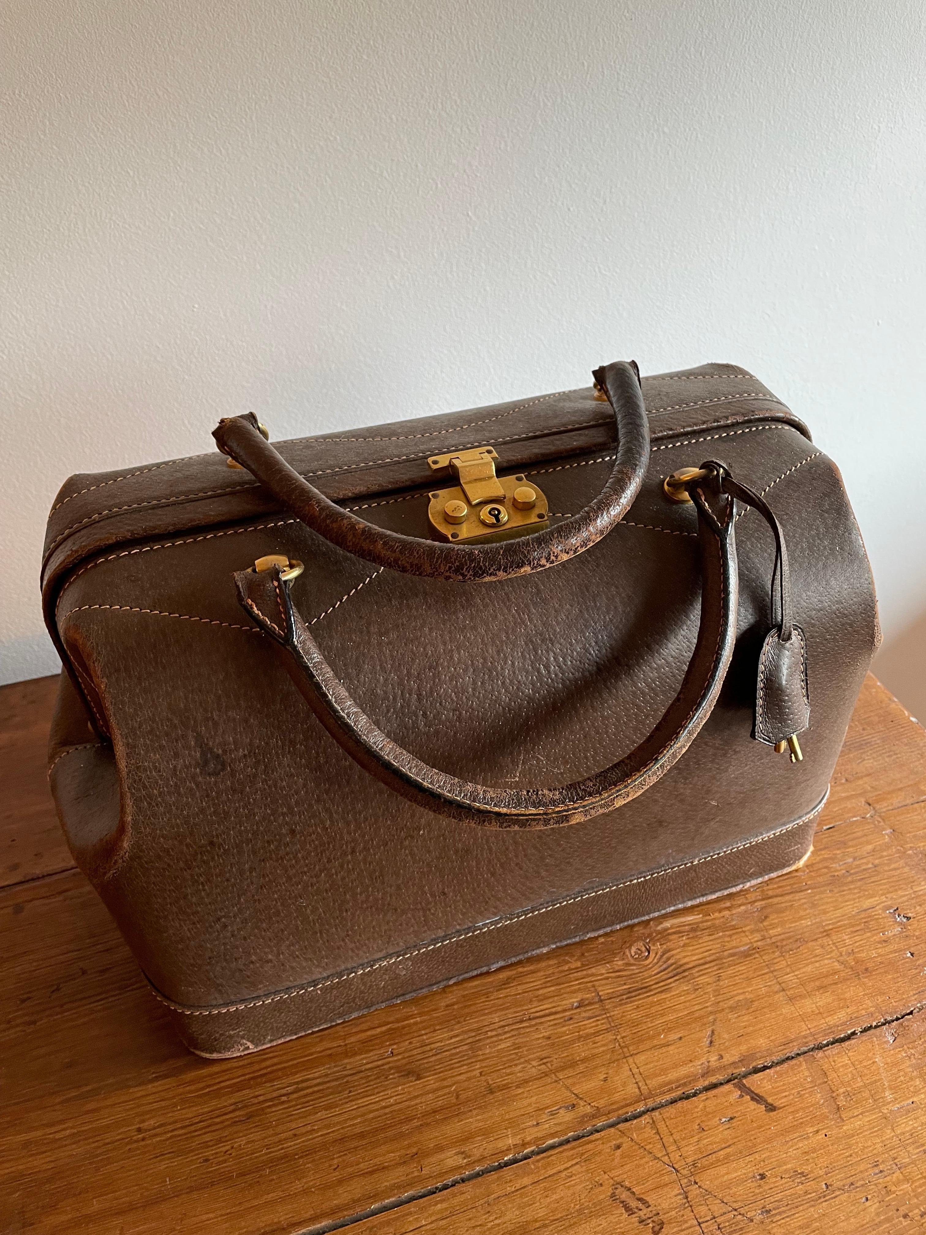 Gucci vintage 60s / 70s trunk in boar leather typical of those years. It has various signs of use as you can see and a handle has come off, but a good craftsman should have no problem fixing it.
Interlocking lock with padlock and original key.