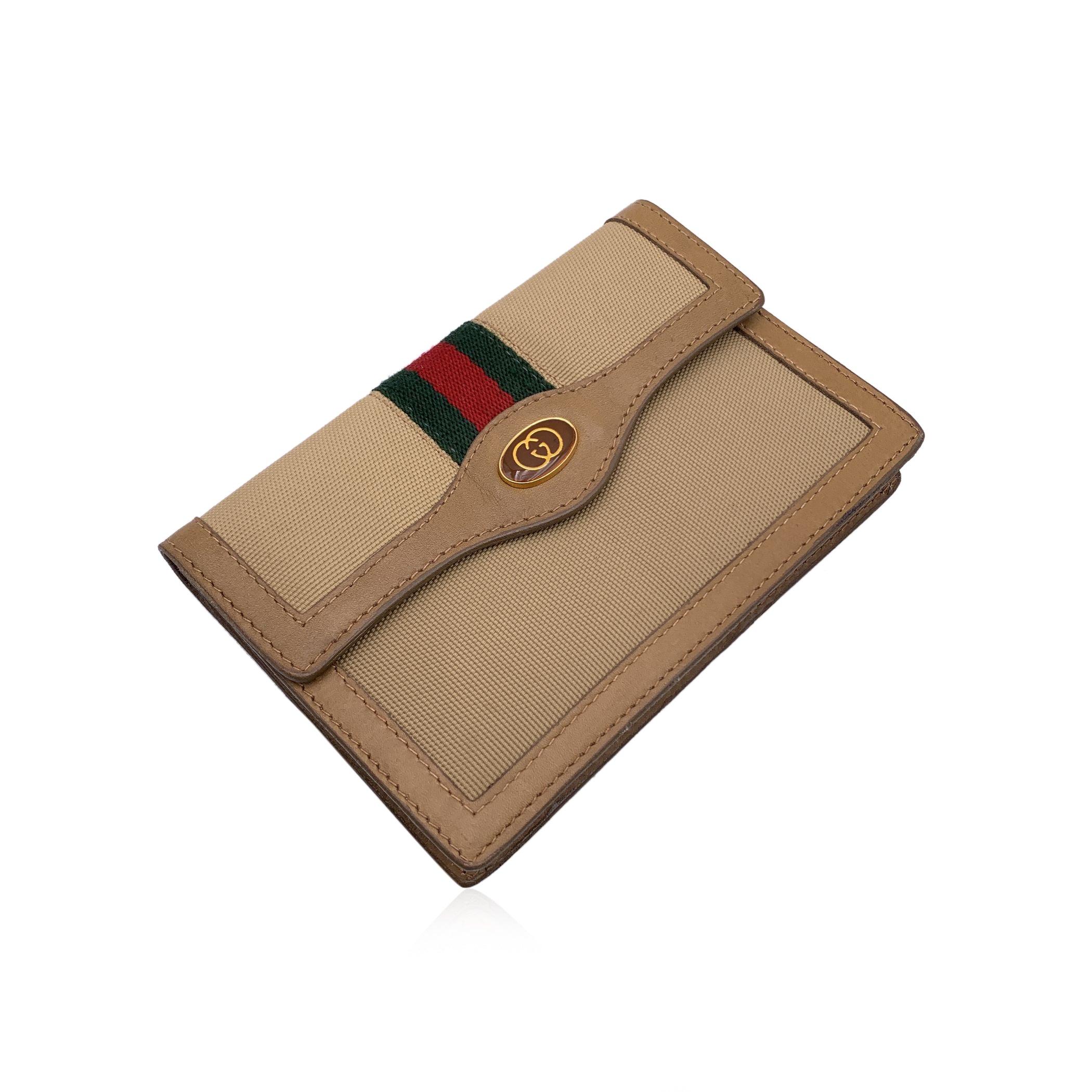Vintage GUCCI beige canvas wallet with green/red/green canvas stripes. GG - GUCCI logo on the front. Flap with button closure.Beige leather lining. 1 main compartment, 2 flat pockets under the flap and 1 side zip pocket internally. 'Gucci Parfums -