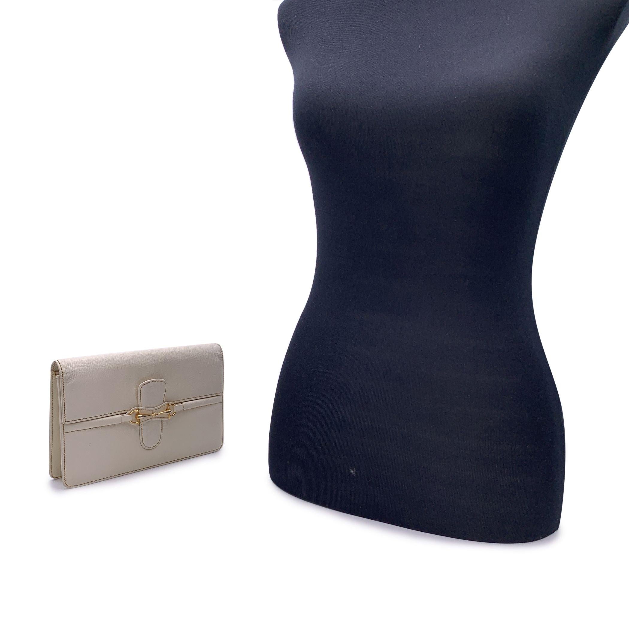 Gucci Vintage beige leather Horsebit clutch bag. Gold metal horsebit detailing on the front. Flap closure. Beige lining. 1 side zip pocket and 3 side open pockets inside. 'Made in Italy by GUCCI' embossed inside Condition B - VERY GOOD Some darkness