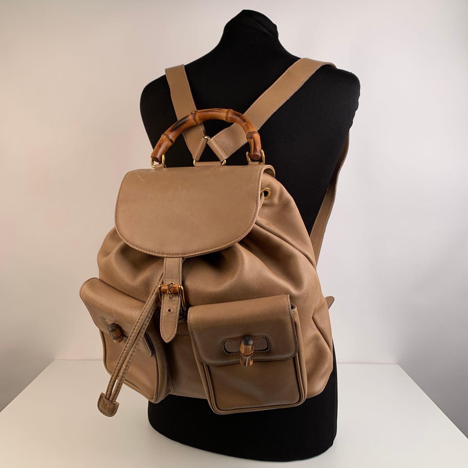 Vintage, beige leather backpack by Gucci. With real Bamboo handle and hardware and knobs. Flap with buckle closure, and drawstring top opening. Gold hardware as well. Internal Gucci diamond monogram pattern (fabric). Side zipper pocket inside (GUCCI