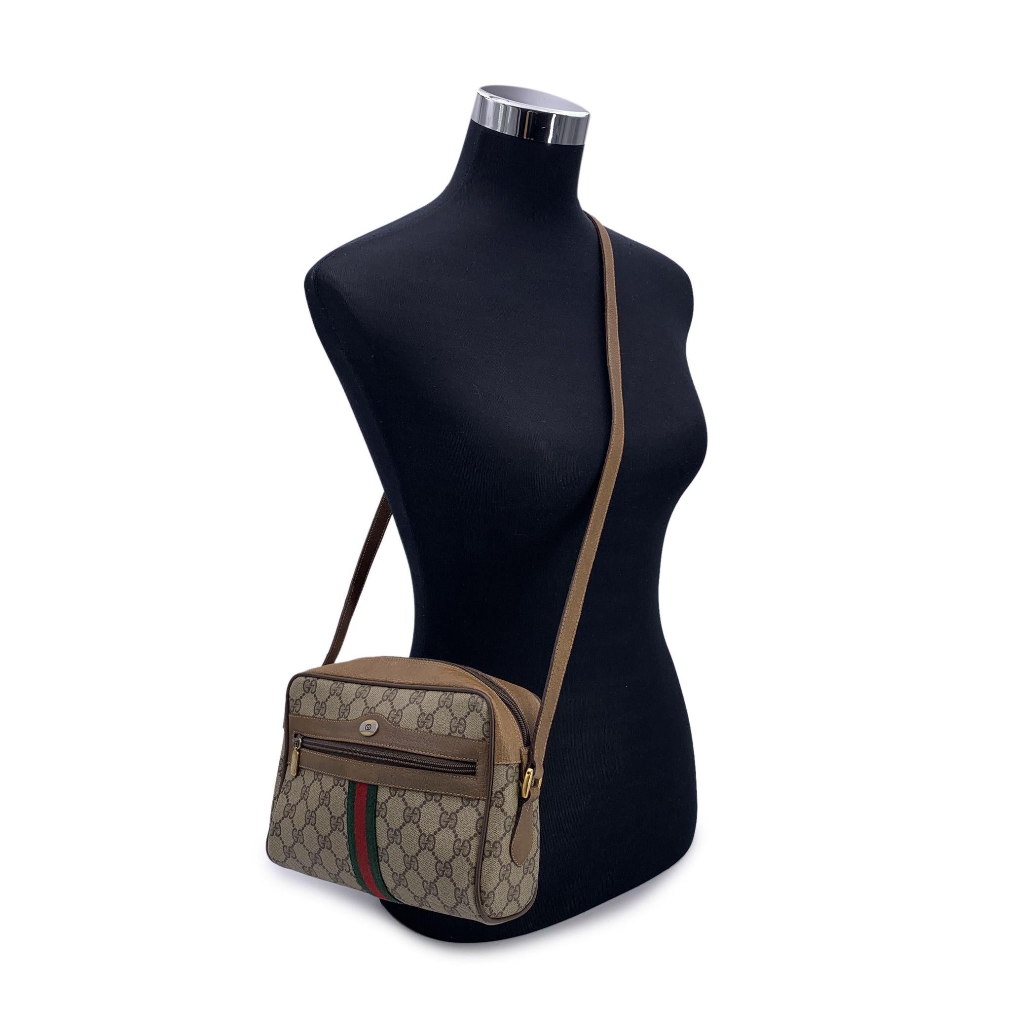 Vintage Gucci 'Ophidia' messenger bag crafted in beige monogram canvas with beige genuine leather trim. Front zip pocket. GG logo tab on the front. Green/Red/Green stripes around the bag. Upper zipper closure. Beige leather lining . Adjustable