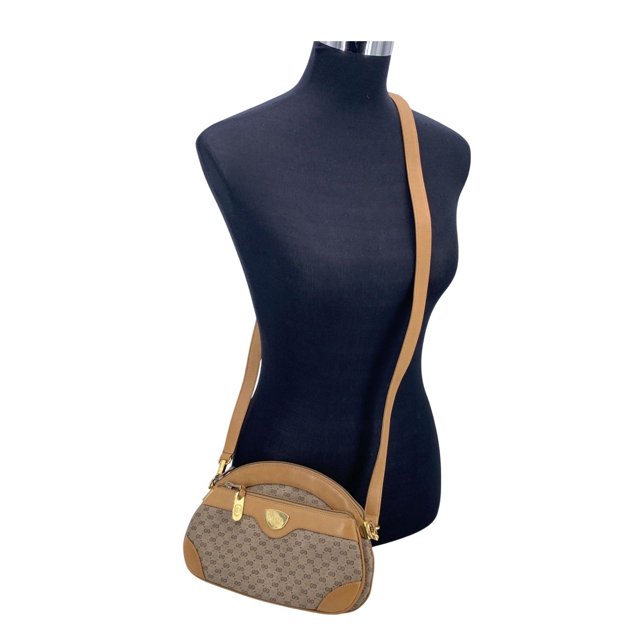Ce sac à bandoulière vintage Gucci Semi Round est une pièce intemporelle qui allie sans effort un style classique au luxe caractéristique de la marque. Confectionné en toile Monogram beige, le sac est joliment rehaussé d'une bordure en cuir