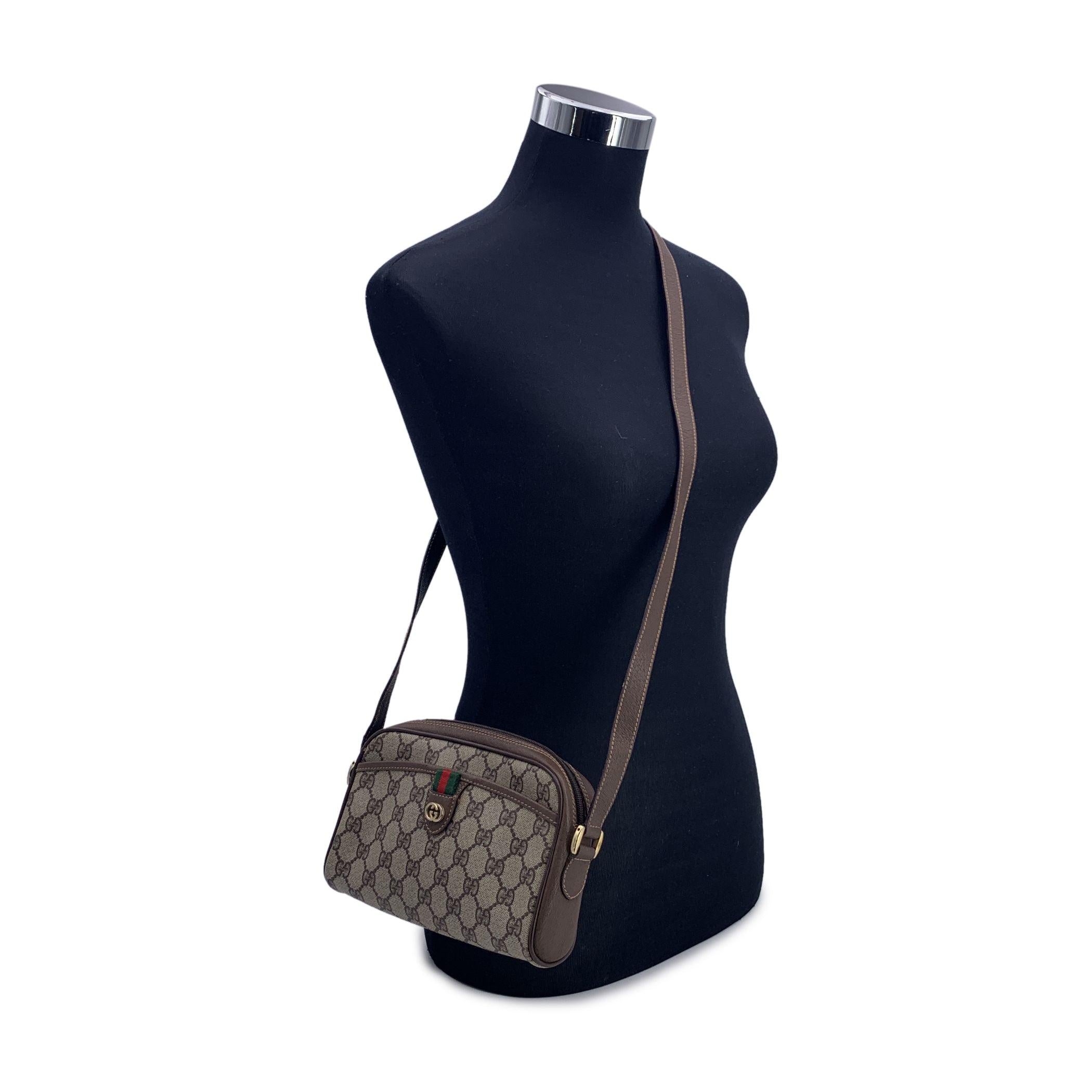 Vintage Gucci crossbody bag. Beige monogram canvas with beige genuine leather trim. 1 pocket on the front with Green/Red/Green GUCCI ribbon detailing. Gold metal GG - GUCCI logo on the front. Upper zipper closure. 1 front open pocket. Beige lining.