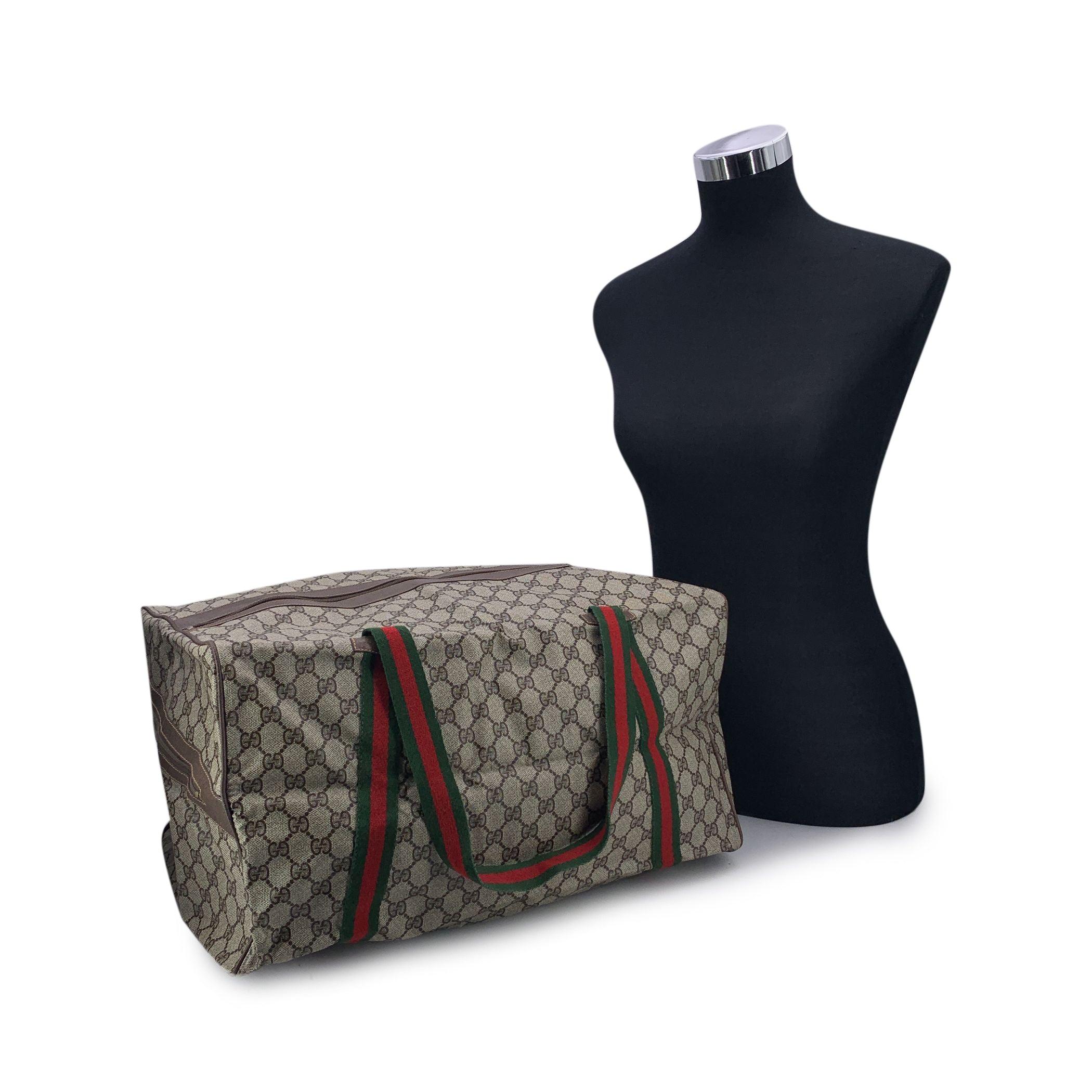 Vintage Gucci folding duffle roomy travel bag. Crafted from brown GG monogram canvas, it's trimmed in brown leather and features an exterior zippered pocket on a side. Iconic green/red/green web canvas and the interior is lined in beige fabric.