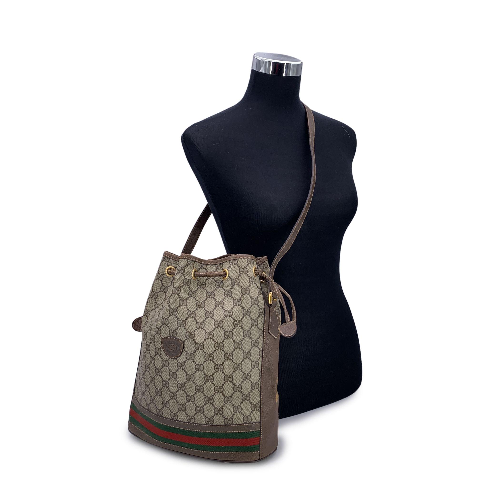 Vintage Gucci Monogram Darwstring bucket bag. Brown monogram canvas with Genuine leather trim and leather shoulder strap.Green/red/green stripes detailing on the bottom. Drawstring closure. Beige lining, 1 side zip pocket inside. Adjustable shoulder