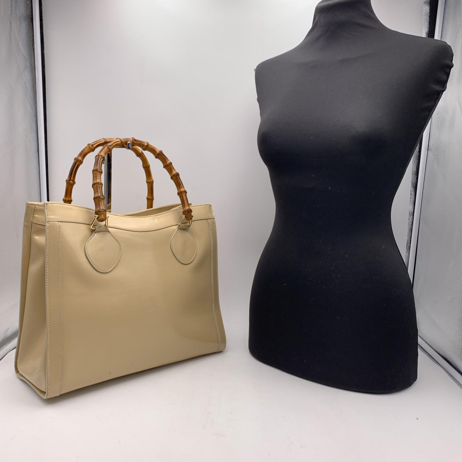 Beautiful Gucci Bamboo tote bag in beige patent leather. Double distinctive Bamboo handle. Princess Diana, was snapped carrying a this model on several occasions. Magnetic button closure on top. 5 bottom feet. Gold metal hardware. 1 Zip compartment