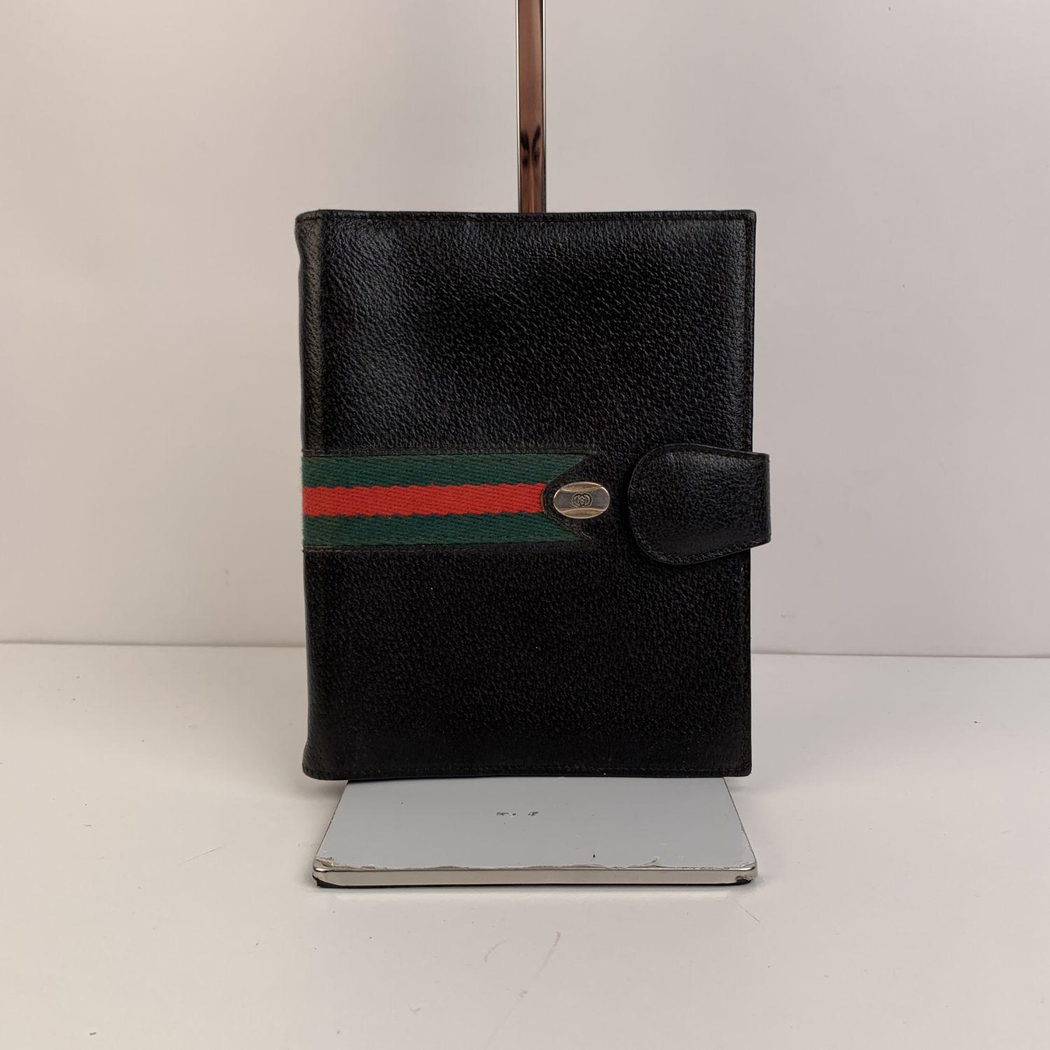 Elegant vintage agenda cover by GUCCI crafted in black leather. Striped detailing on the cover. It features a four ring binder inside and 6 side open slot inside. 'GUCCI Accessory collection - made in Italy' embossed inside. Measurements: 7.5 x 6