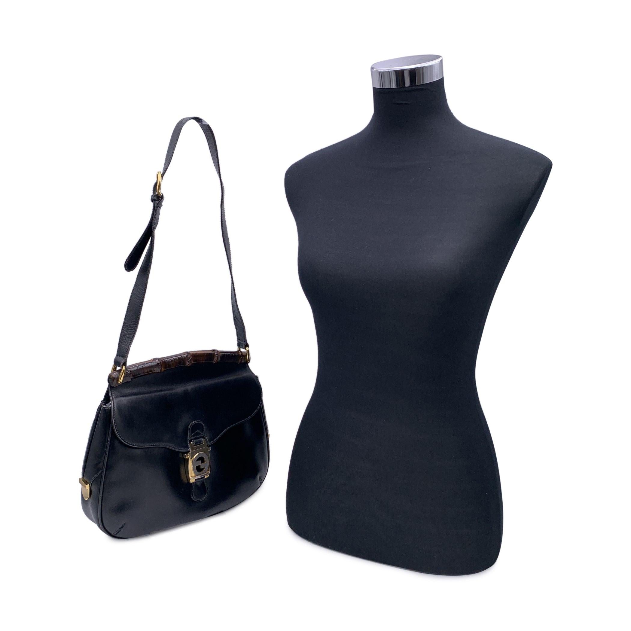 Beautiful Vintage Gucci bamboo shoulder bag crafted in black leather. Bamboo accent on top. Flap with interlocking GG clasp closure.Adjustable shoulder strap. Black leather lining. 1 side open pocket and 1 side zip pocket inside. 'Made in Italy by