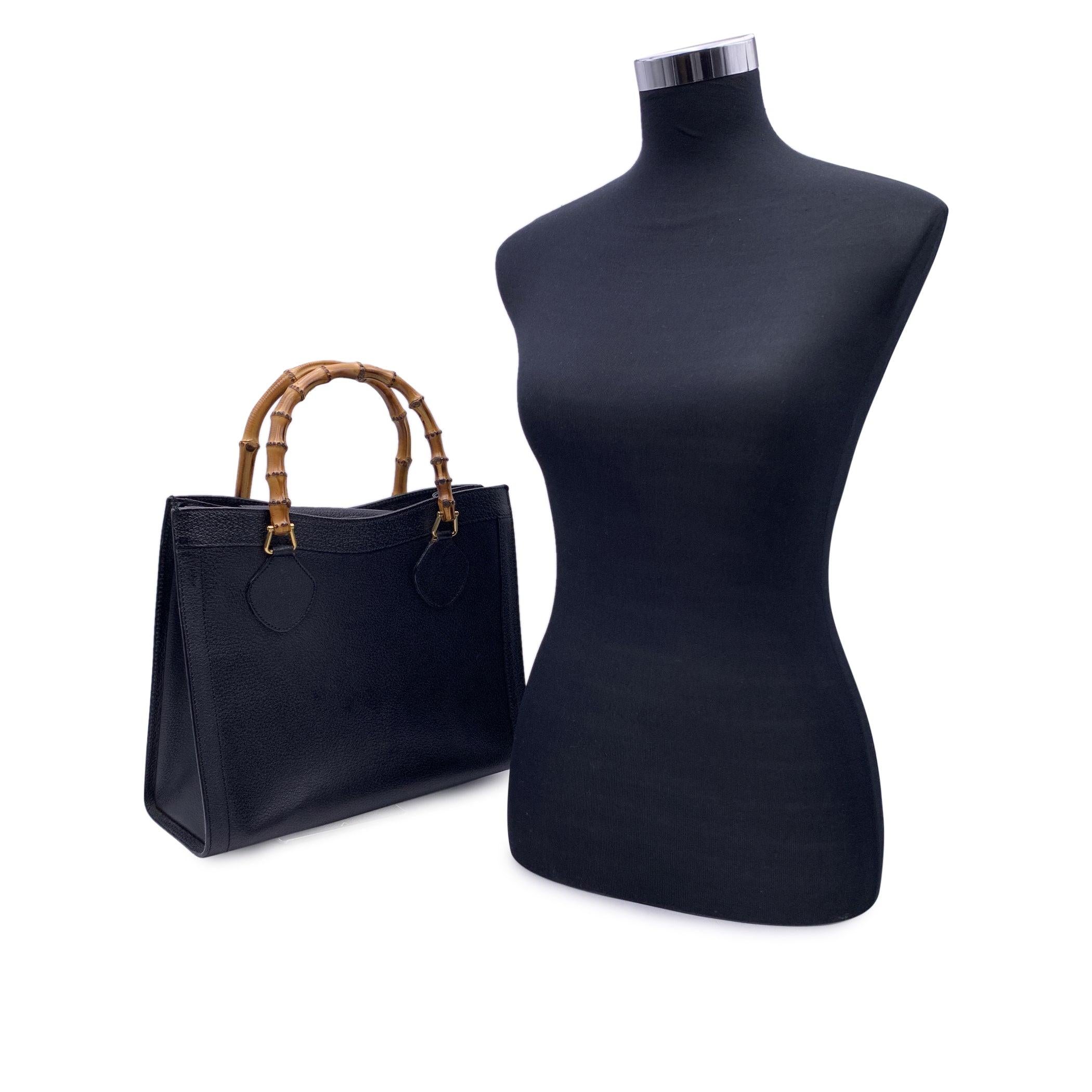 Beautiful Gucci Bamboo tote bag in black leather. Double distinctive Bamboo handle. Princess Diana, was snapped carrying a this model on several occasions. Magnetic button closure on top. 5 bottom feet. Gold metal hardware. 1 side zip pocket inside.